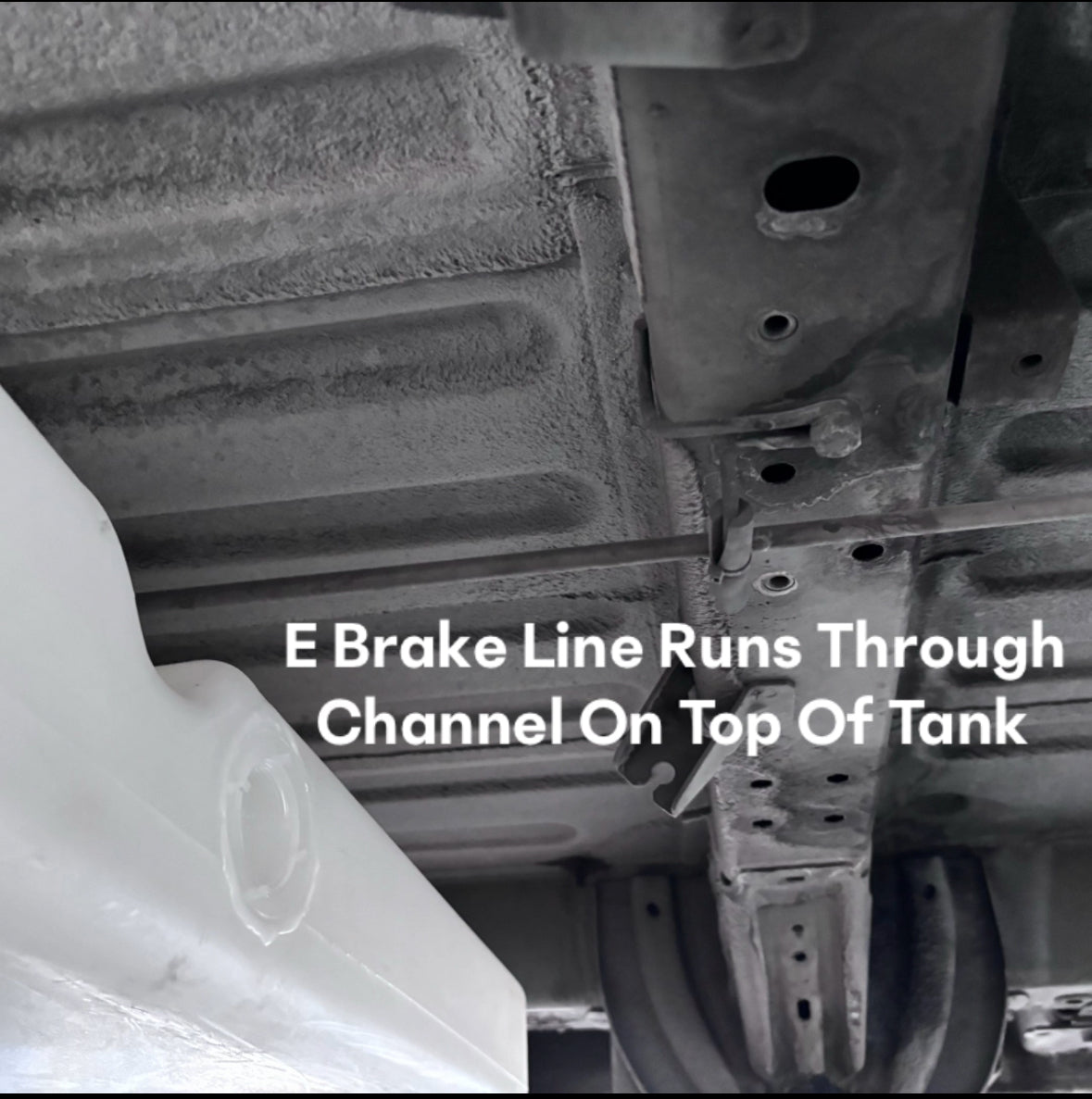 Undercarriage view showing a 36-gallon fresh/grey water tank for Ford and Dodge vehicles, highlighting the E-brake line channel.