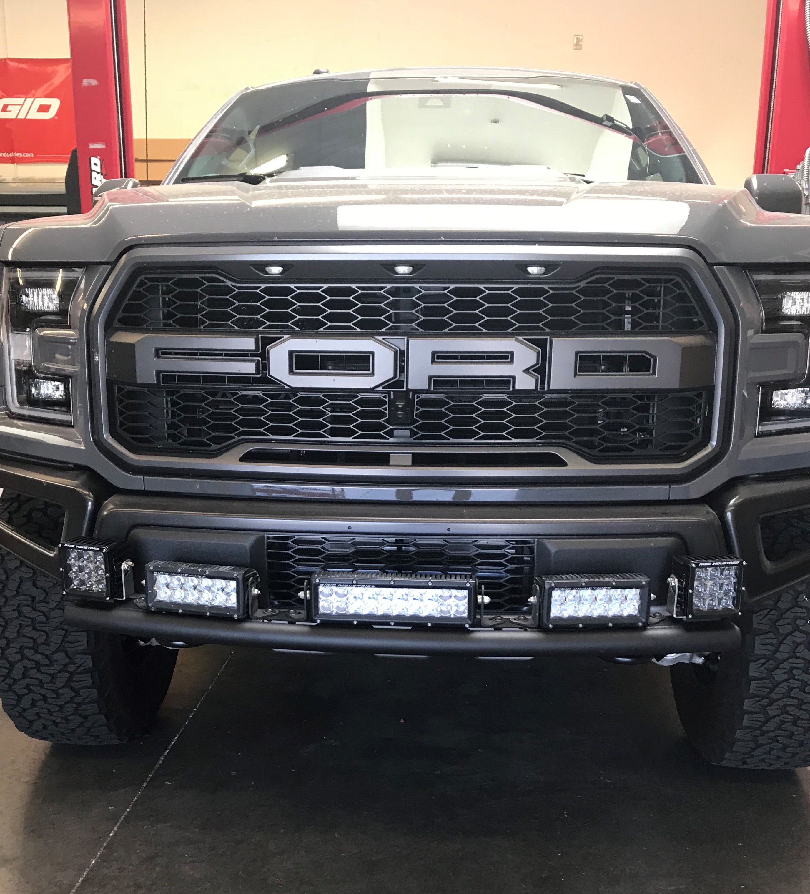 Single tube light mount for 2015+ F150 and 2017+ Raptor, installed on stock bumper, showcasing front view with lights.