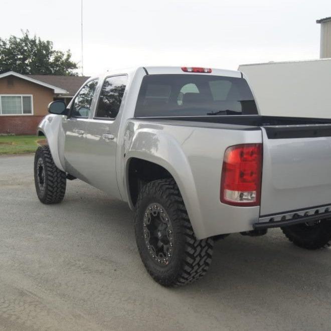 2007-2013 GMC Sierra with aftermarket bedsides and off-road tires, showcasing a rugged and lifted design.