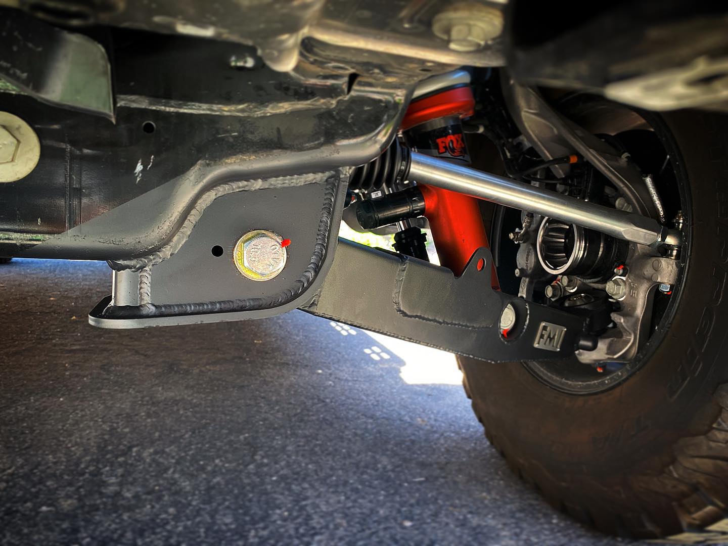 Raptor lower arm pocket replacement kit by Foutz Motorsports installed on a truck's suspension system.