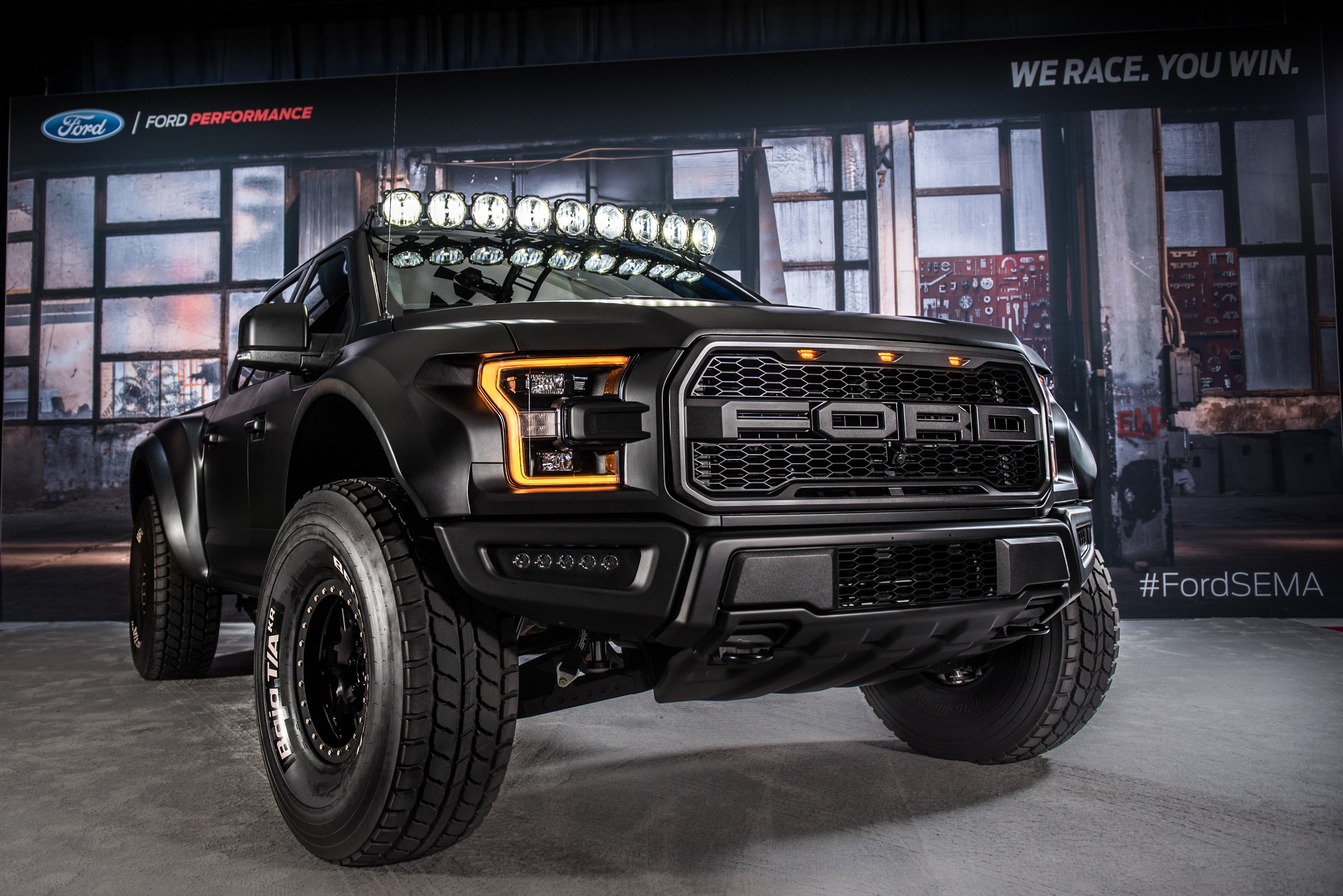 2017 Up Raptor Long Travel Front Suspension Kit displayed on a modified Ford Raptor at an automotive event.