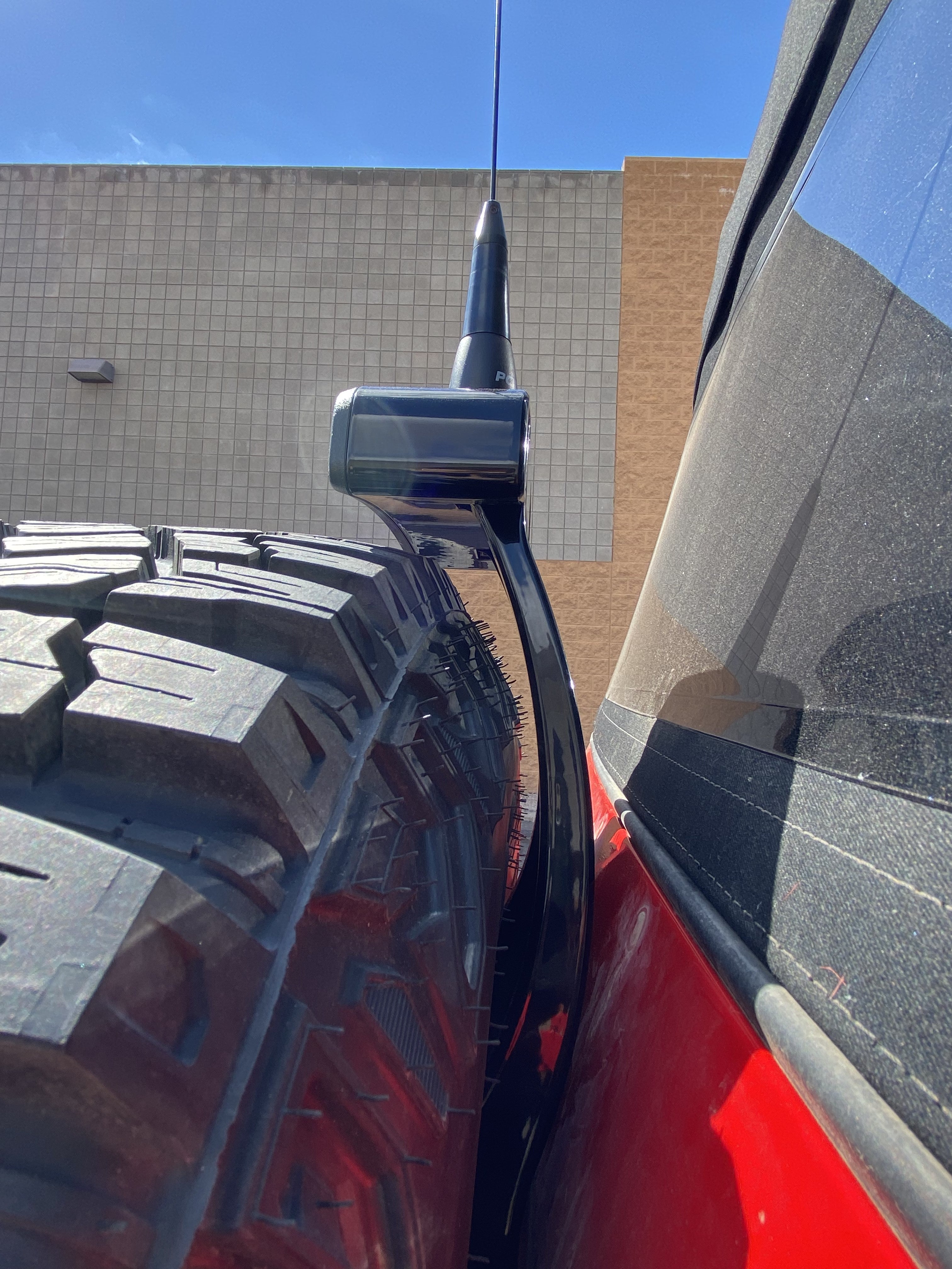 2021-25 Ford Bronco third brake light antenna mount installed on a vehicle with a large tire, showcasing durability and design.