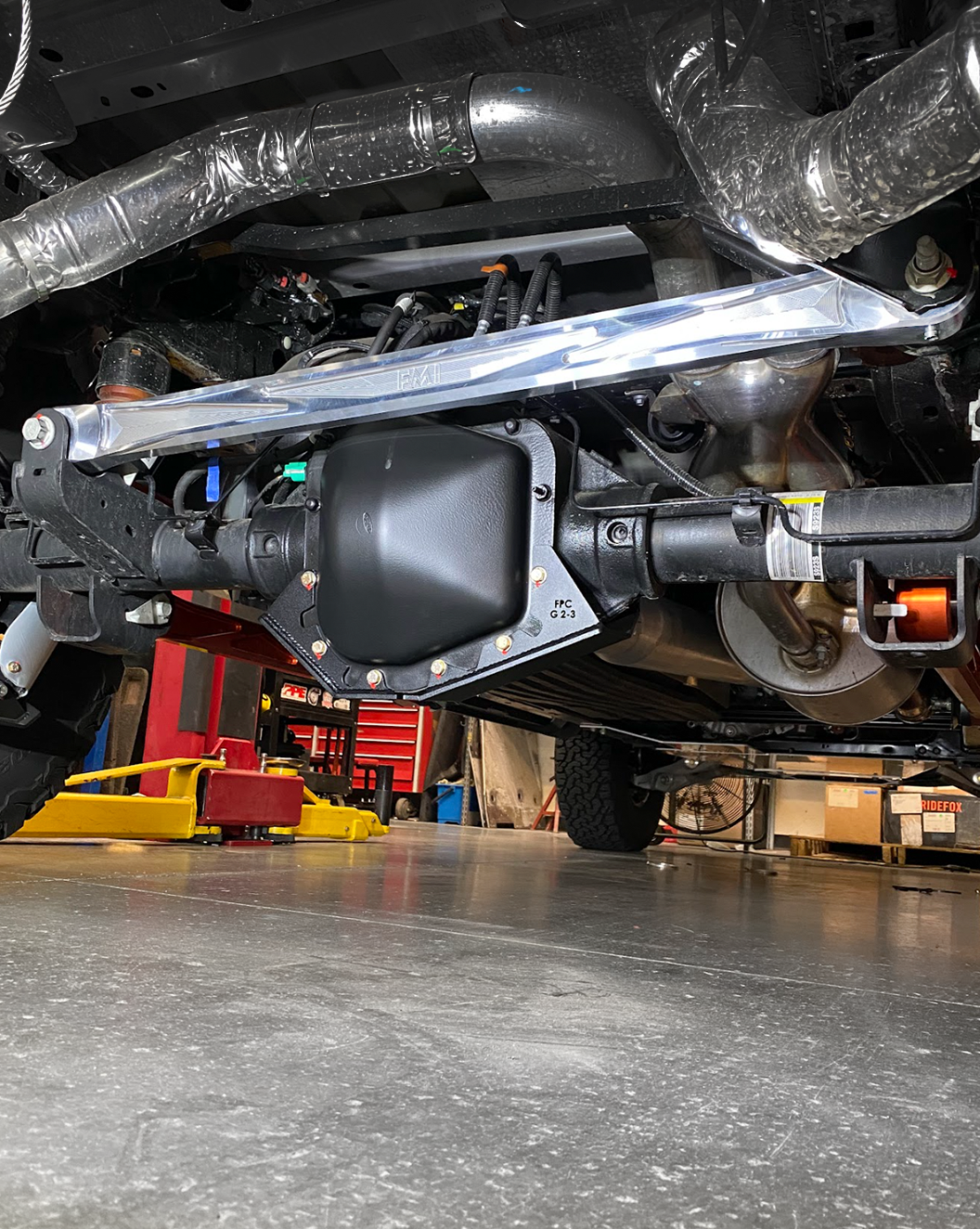 2021-2024 F150 Raptor billet panhard bar with ultra-flex joint installed under a vehicle, showcasing durability and performance.