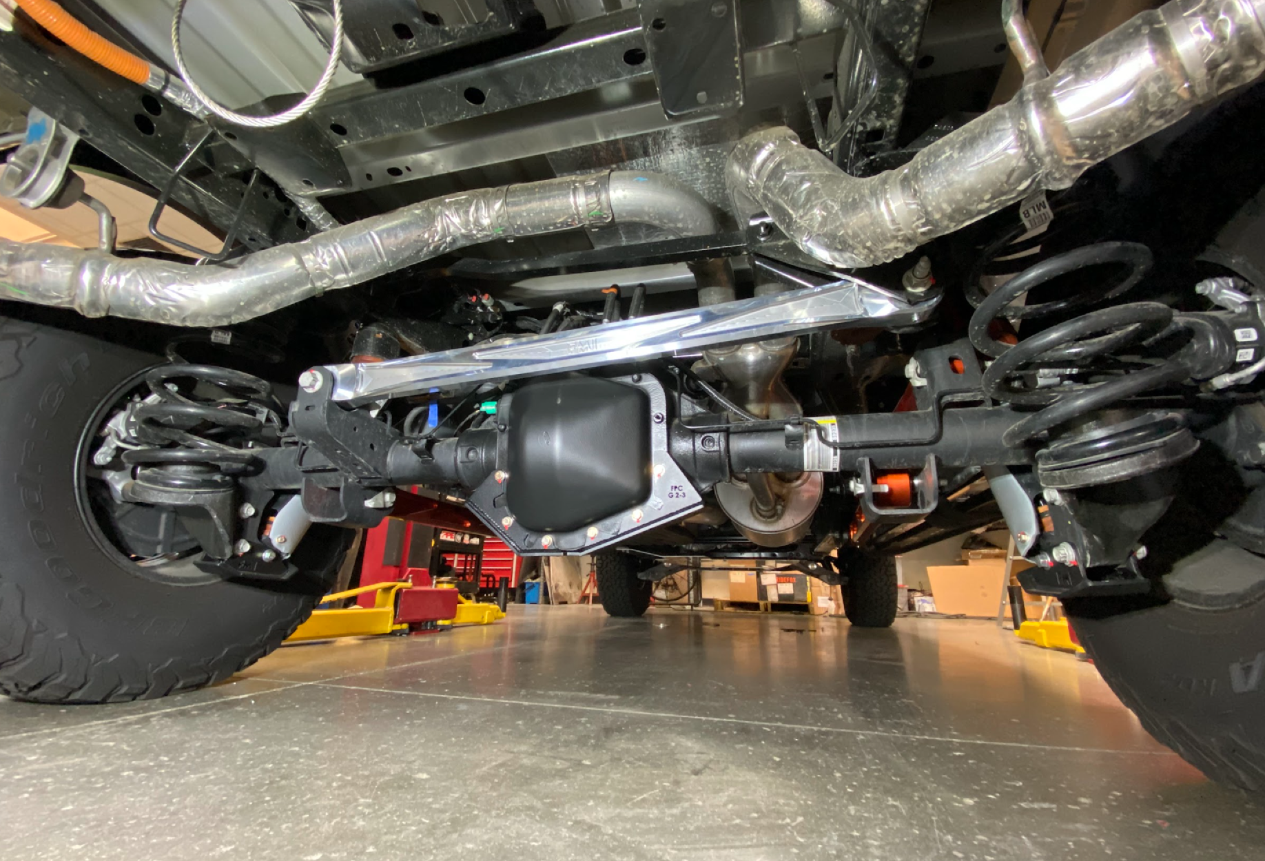 2021-2024 F150 Raptor billet panhard bar with ultra-flex joint installed, showcasing suspension and axle components.