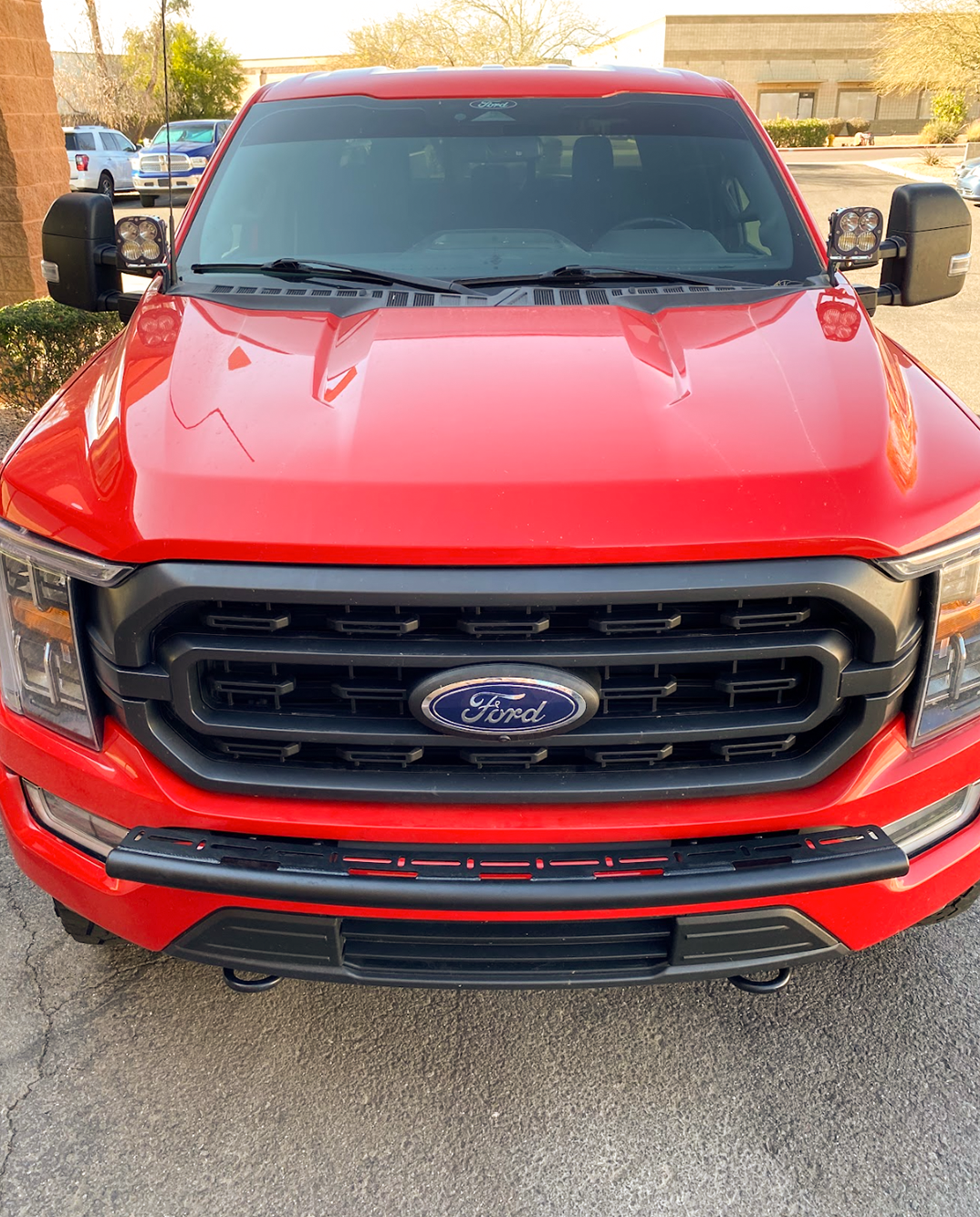 Front view of a red 2021-2023 Ford F150 showcasing a front light mount compatible with the stock bumper.