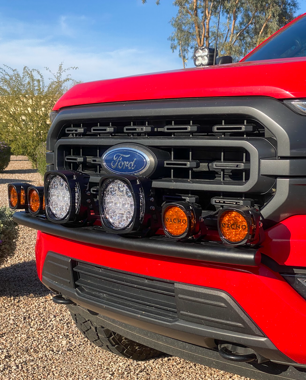Front light mount for 2021-2023 Ford F150, featuring multiple off-road lights on a stock bumper. Ideal for enhanced visibility.