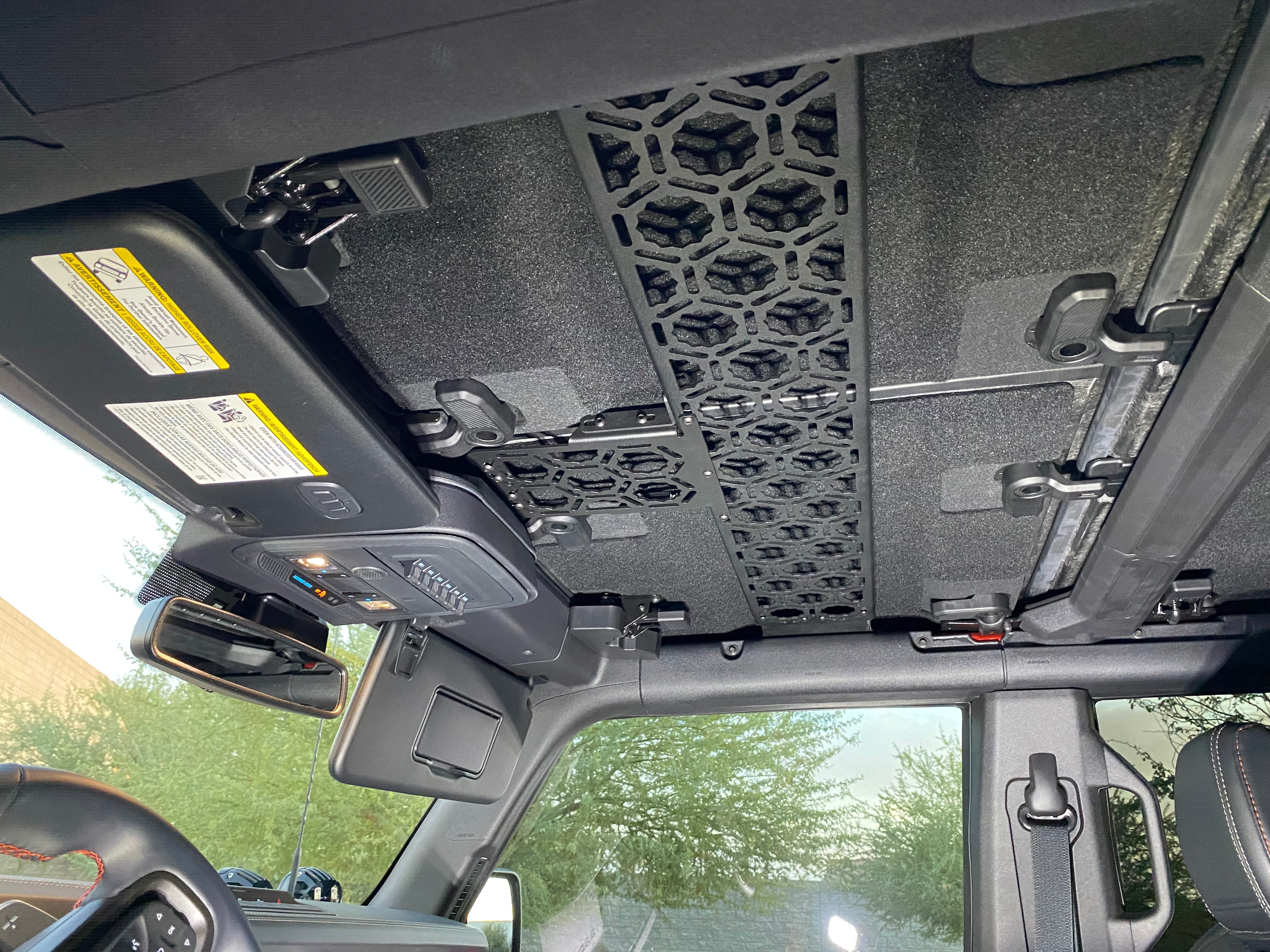 Inside view of a 2021 Bronco featuring the Adapt-A-Panel roof mount, designed for storage across the front seats.