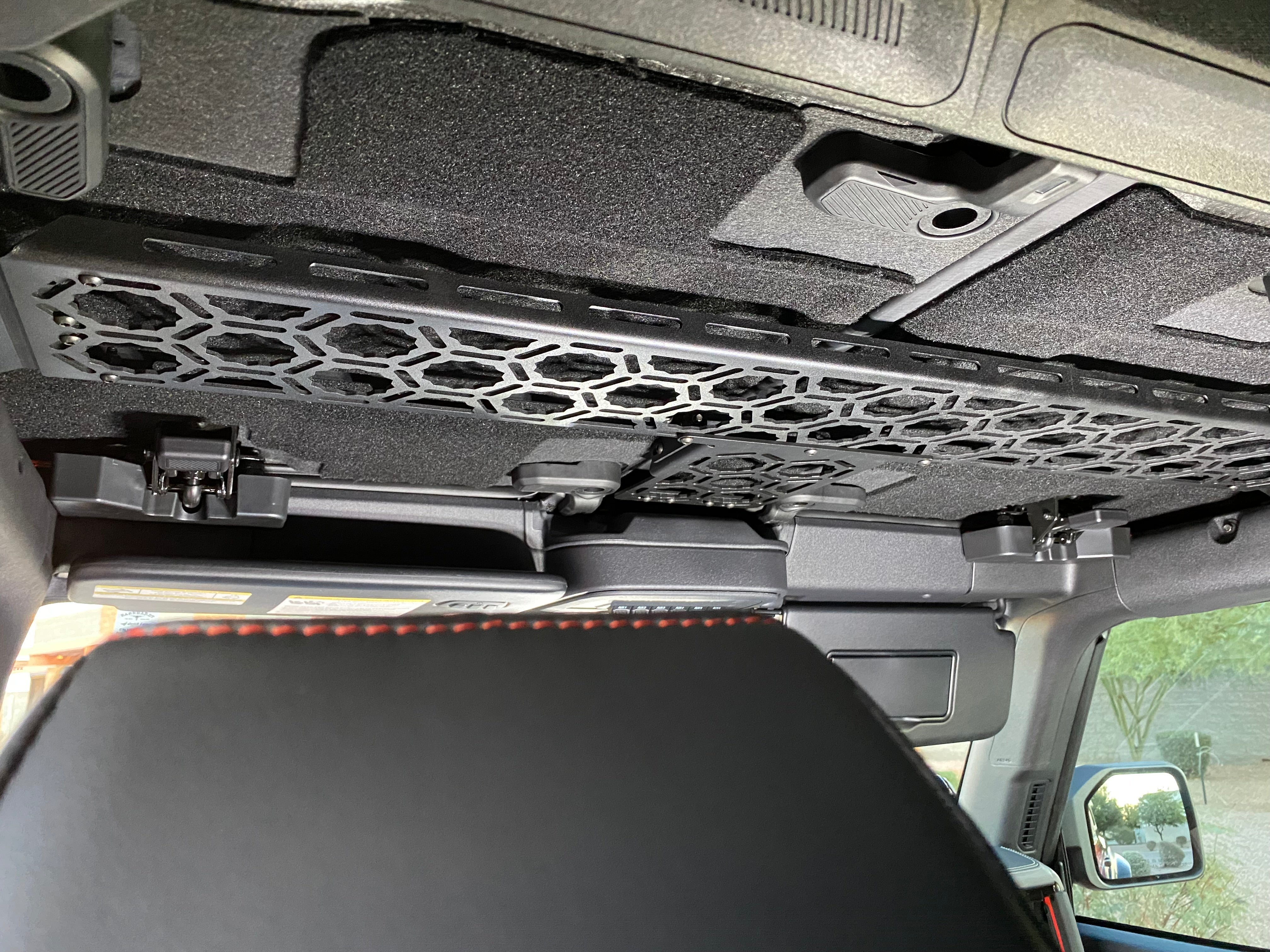 Inside view of a 2021 Bronco featuring an Adapt-A-Panel roof mount across the front seats, designed for storage solutions.