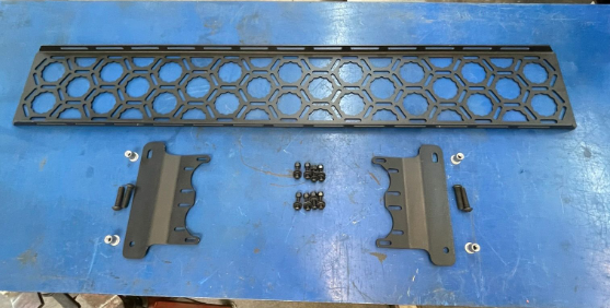 Bronco 2021 Inside Roof Panel Mount by Adapt-A-Panel, featuring a hexagonal design and mounting hardware on a blue surface.