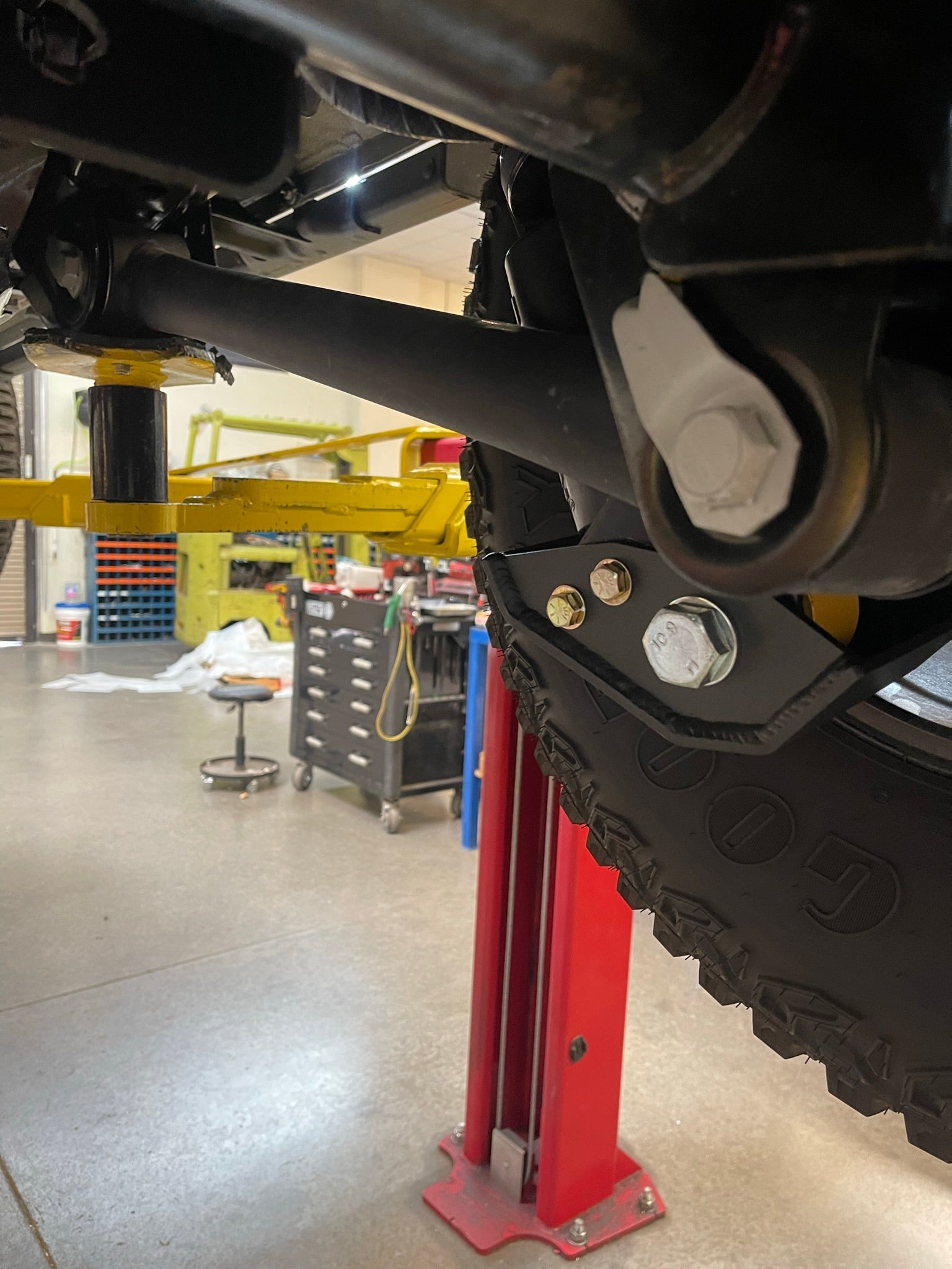 2021+ Bronco rear shock skid kit installed, showcasing durable protection for Squatch and Base shocks in a workshop setting.