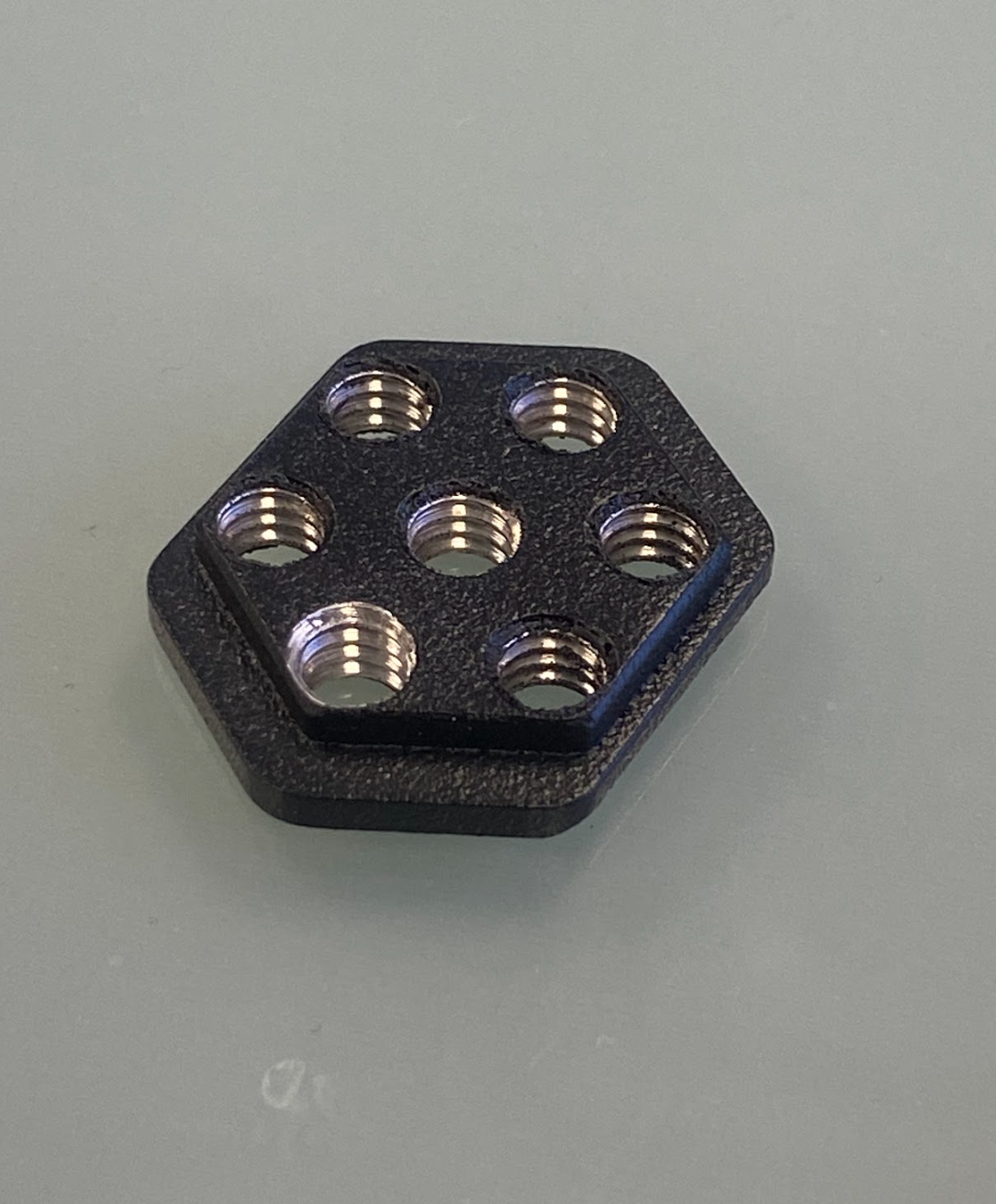 2024 F150 Raptor center dash mount kit by Adapt-A-Panel featuring a hexagonal black plate with multiple threaded holes.