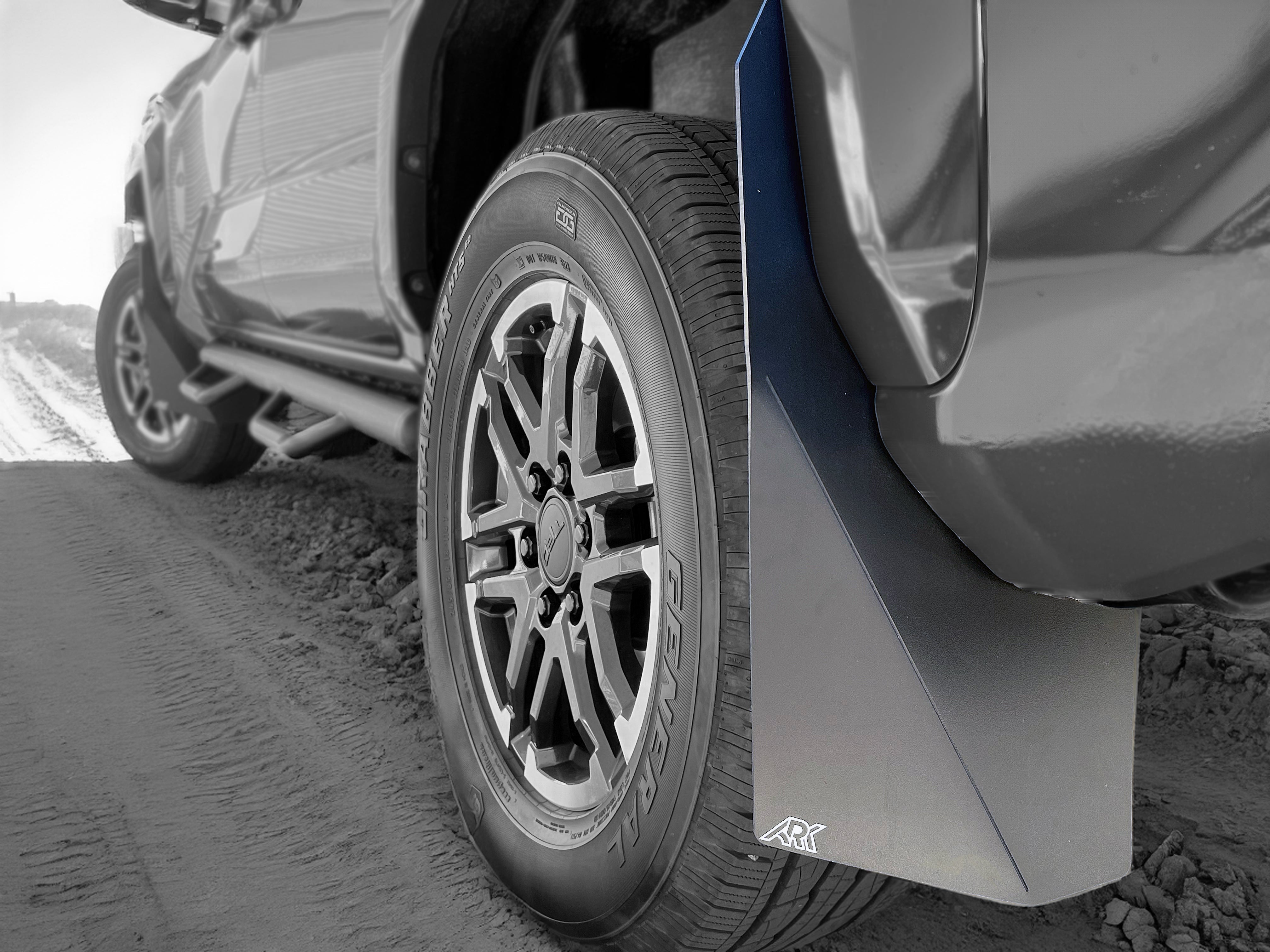 2024+ Toyota Tacoma TriXpoly splash guards and mudflaps installed on a truck tire, providing protection from mud and debris.