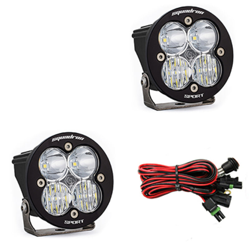 Baja Designs Squadron R Sport LED light pods with clear lenses, featuring a compact design and wiring harness.
