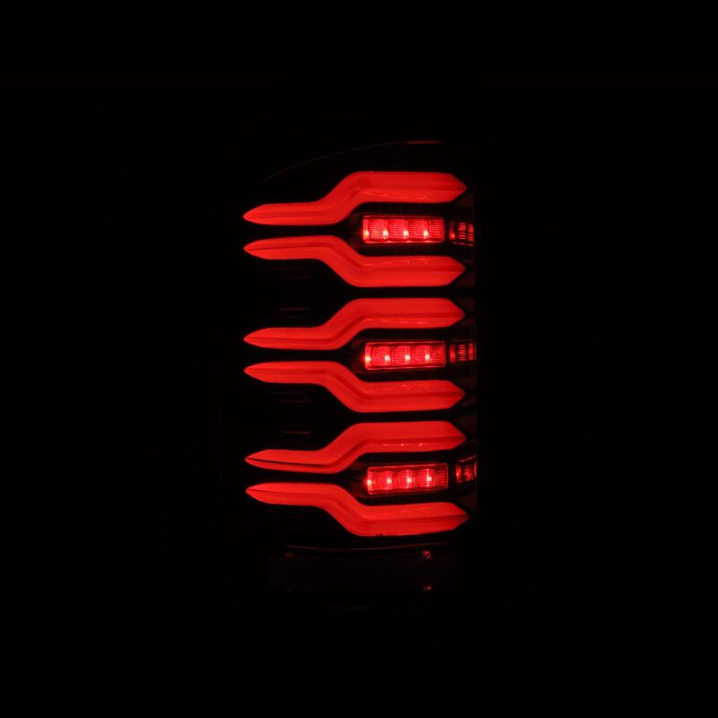 AlphaRex LUXX-Series LED tail lights for 14-18 GMC Sierra 1500/2500HD/3500HD with sequential signal and black housing.