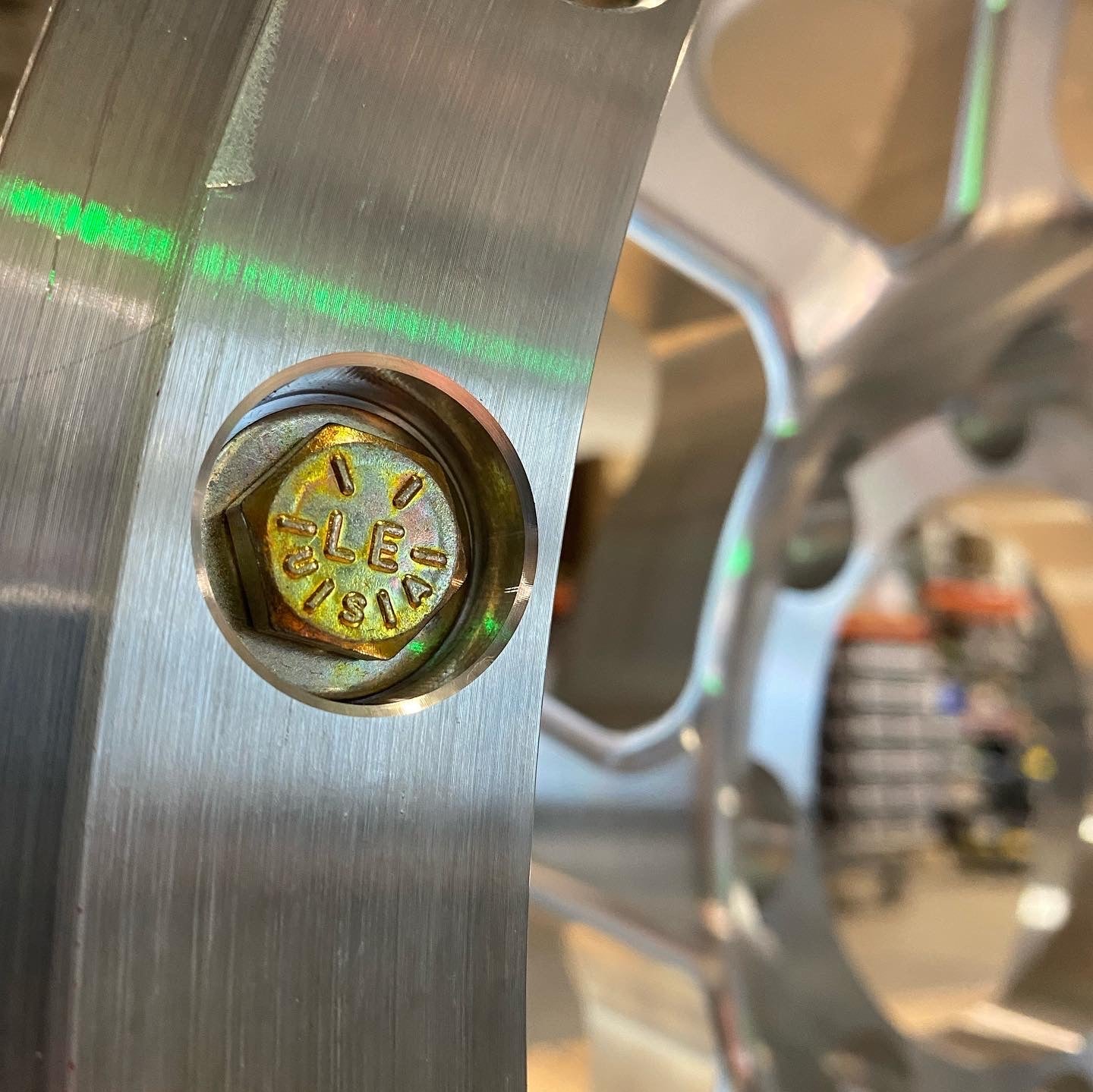 Close-up of aluminum beadlock hardware kit showcasing a detailed nut on a wheel rim, emphasizing durability and design.