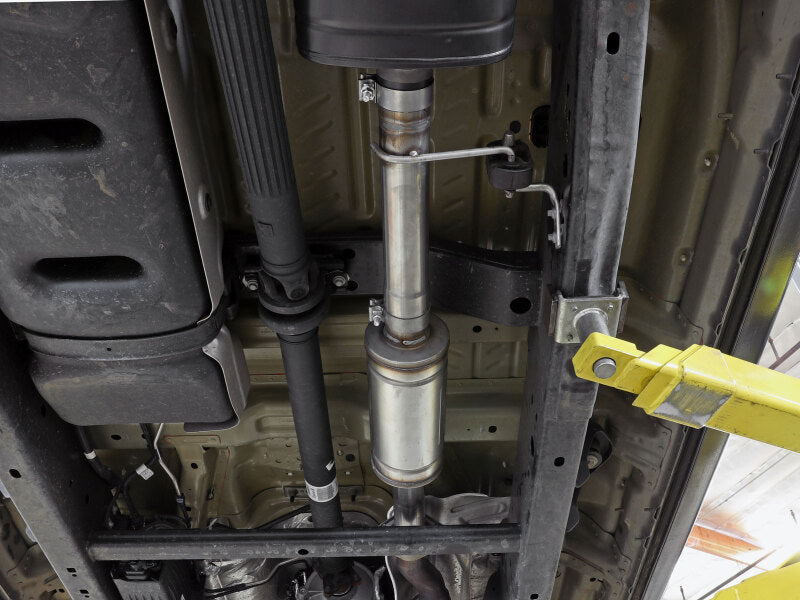 aFe Vulcan Series resonator upgrade pipe installed in a vehicle's exhaust system, showcasing its stainless steel construction and design.