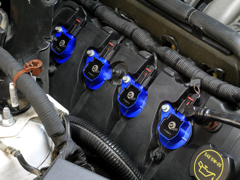afe SCORCHER ignition coils installed in a Ford Mustang or F-150 V8 engine, showcasing their blue design and placement.