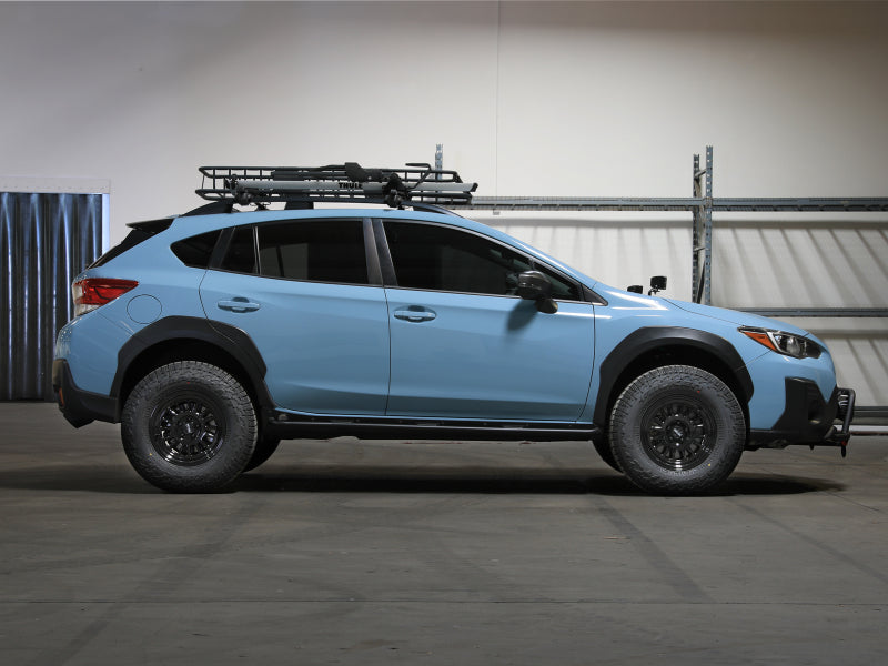 aFe 18-23 Subaru Crosstrek CONTROL 1.5in Lift Kit installed on a blue Subaru Crosstrek with off-road tires and roof rack.