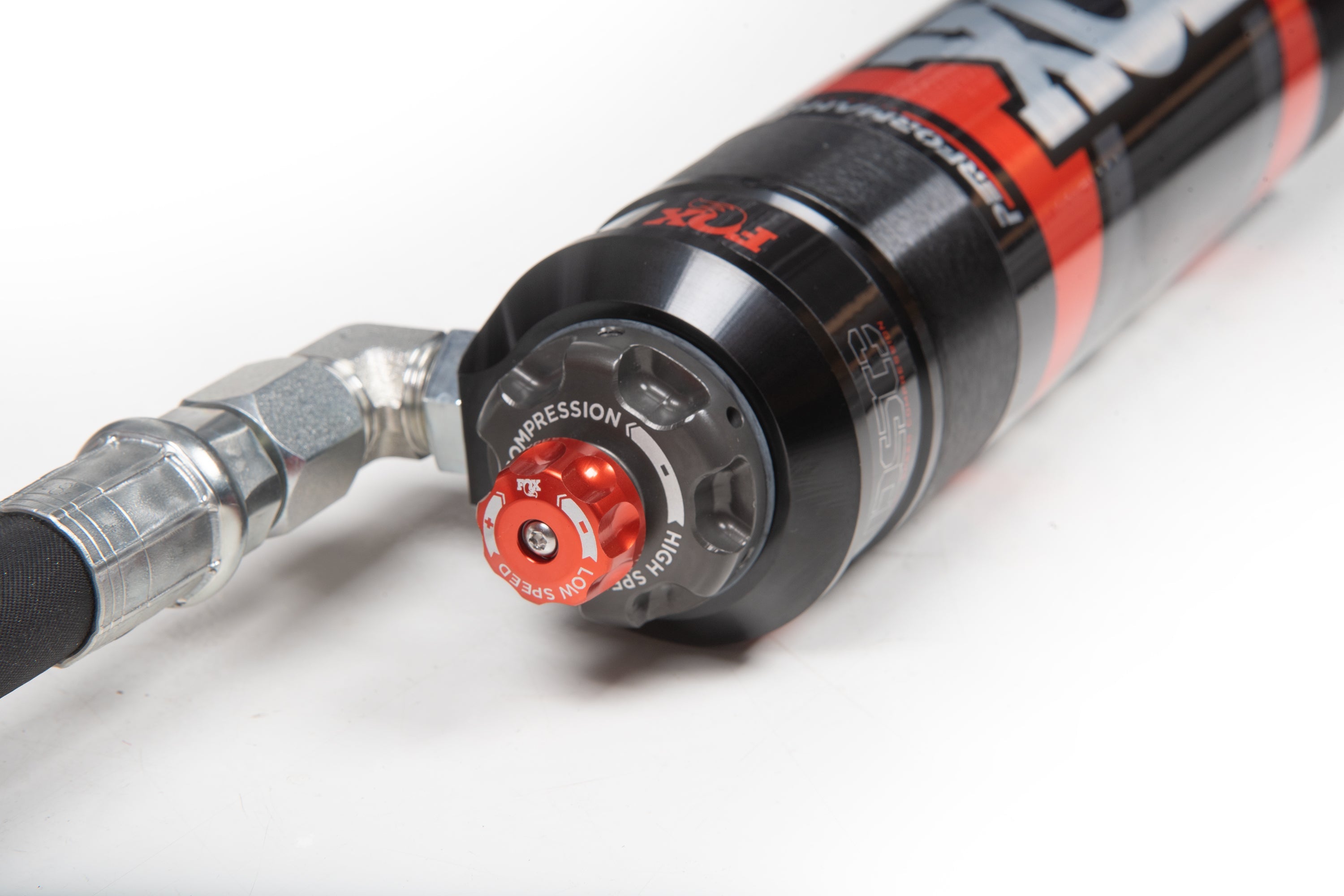 Close-up of FOX 2.5 Performance Elite Coil-Over shock for Toyota Tundra 3 Inch Lift Kit, showcasing adjustment knob and fittings.