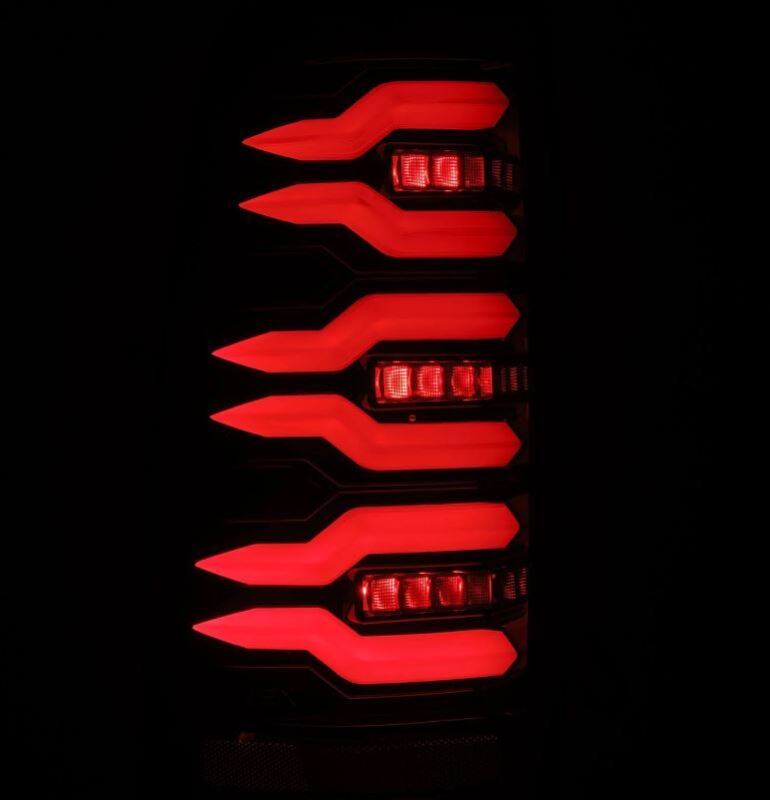 AlphaRex LUXX-Series LED tail lights for 99-06 Chevrolet Silverado and GMC Sierra in black, showcasing bright red illumination.