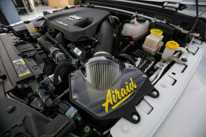Airaid performance air intake system installed in a 2020-2021 Jeep Wrangler V6 engine compartment with hardware included.