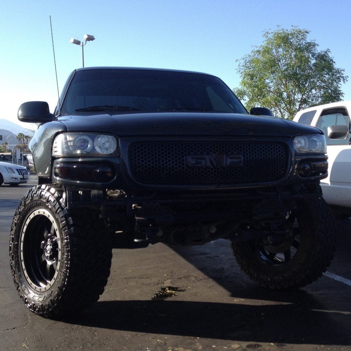 2000-2006 GMC Sierra fenders showcasing a lifted black truck with offroad tires and a rugged appearance.