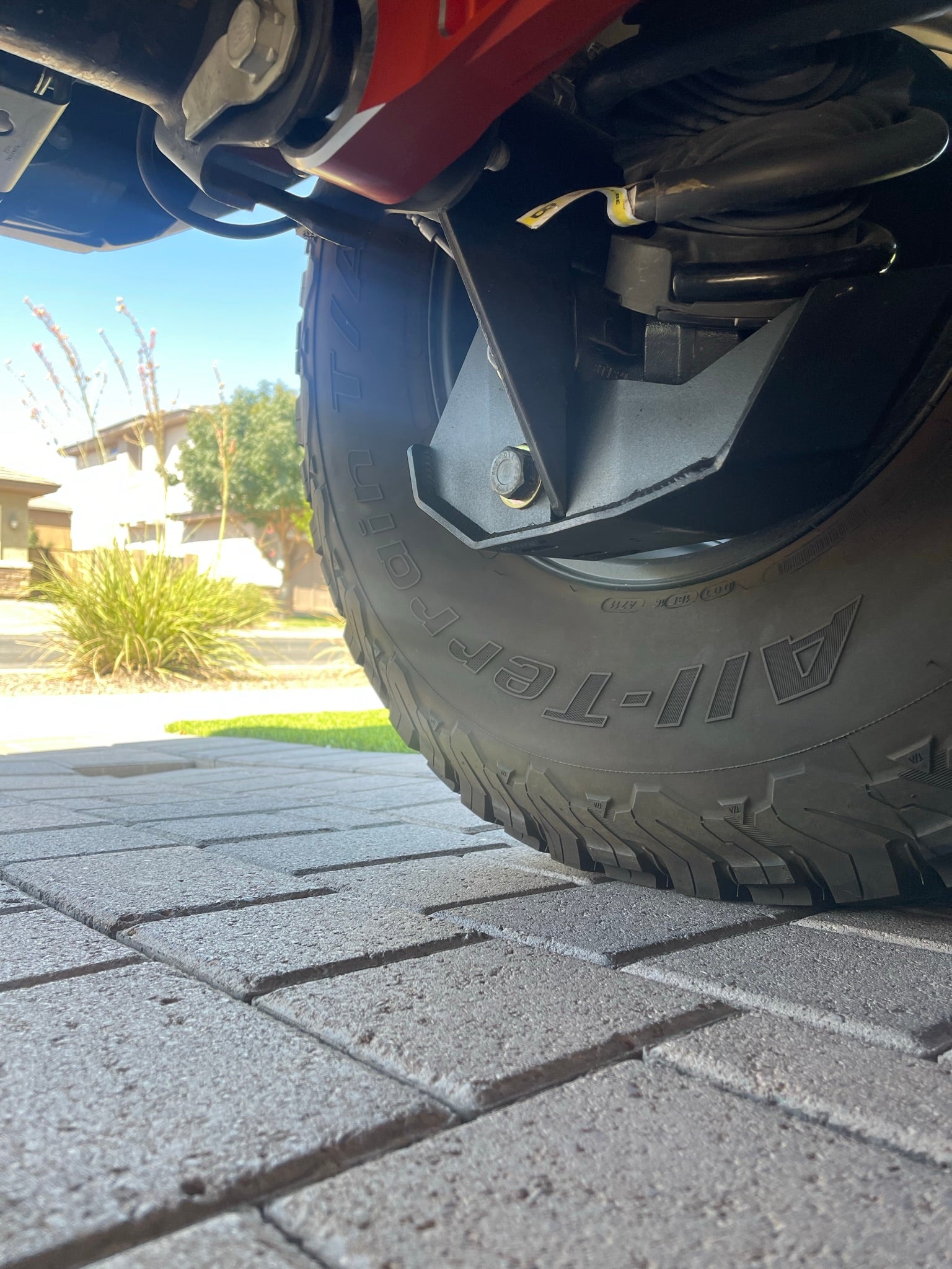 2022 and newer Bronco Raptor rear shock skid kit installed, showcasing tire and suspension components.