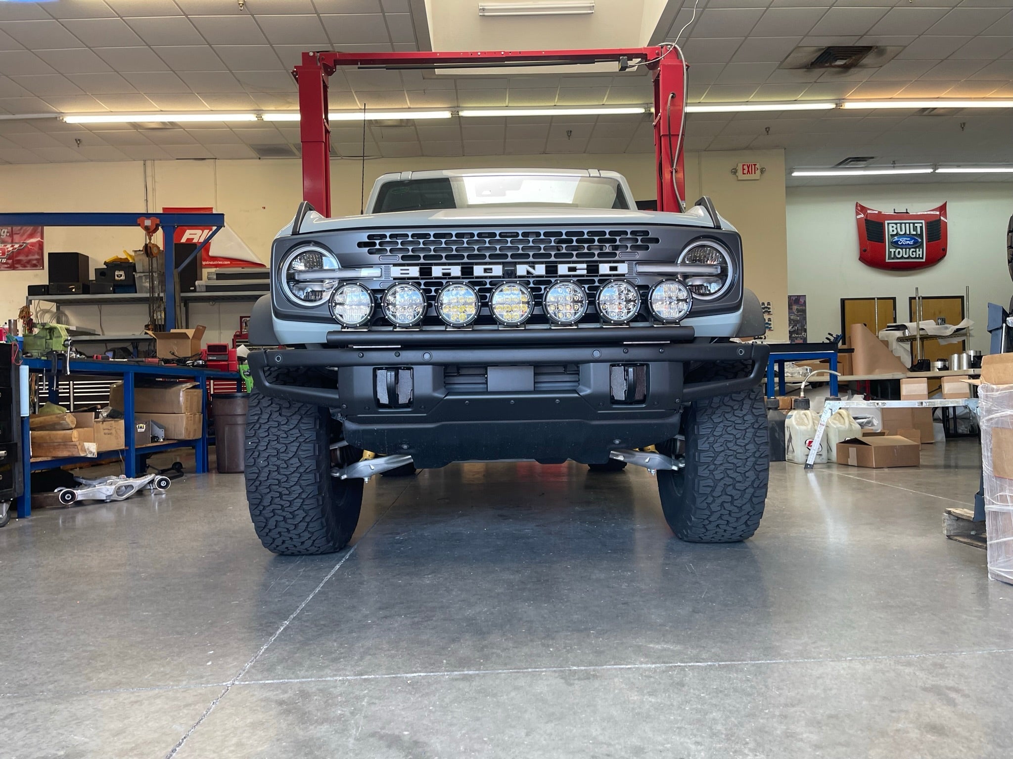 Front view of a 6th Gen Bronco with a Front Light Mount Kit installed on a modular stock bumper, showcasing multiple light options.