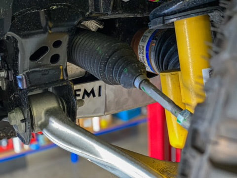 Close-up of a 2021 Ford Bronco skid plate showcasing its durable design and installation near suspension components.