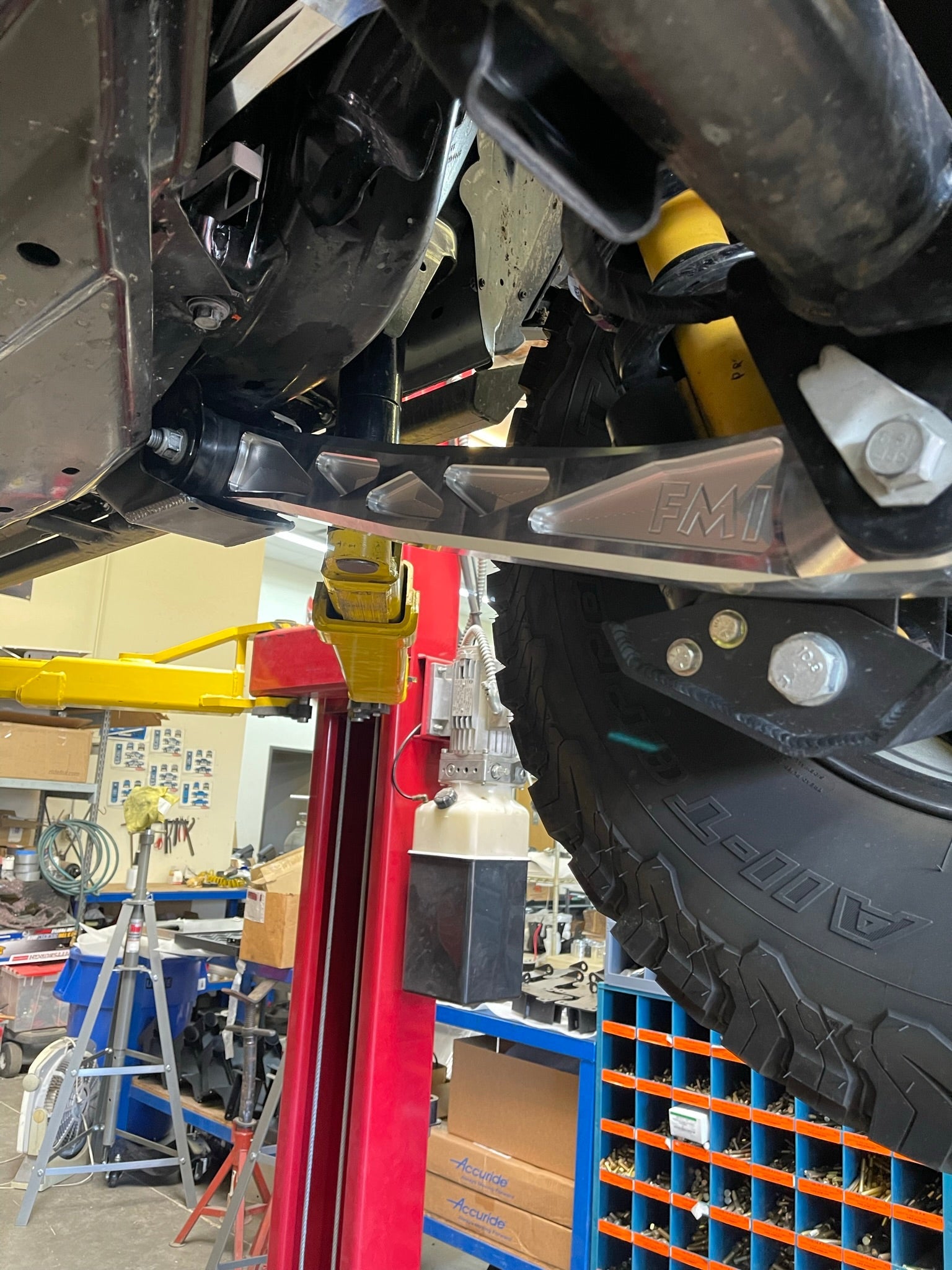 Bronco rear suspension kit featuring billet aluminum rear arms installed on a vehicle in a workshop setting.