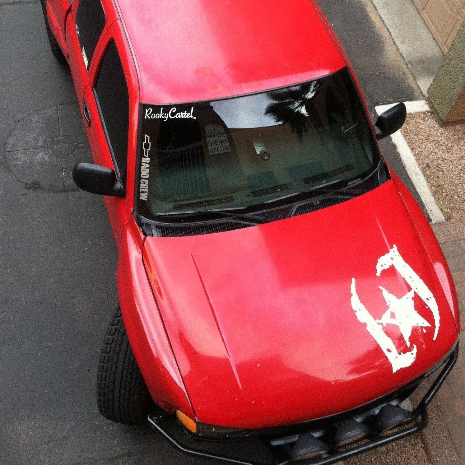 Red GMC Sierra parked, showcasing custom fenders designed for 2000-2006 models, highlighting offroad style and durability.