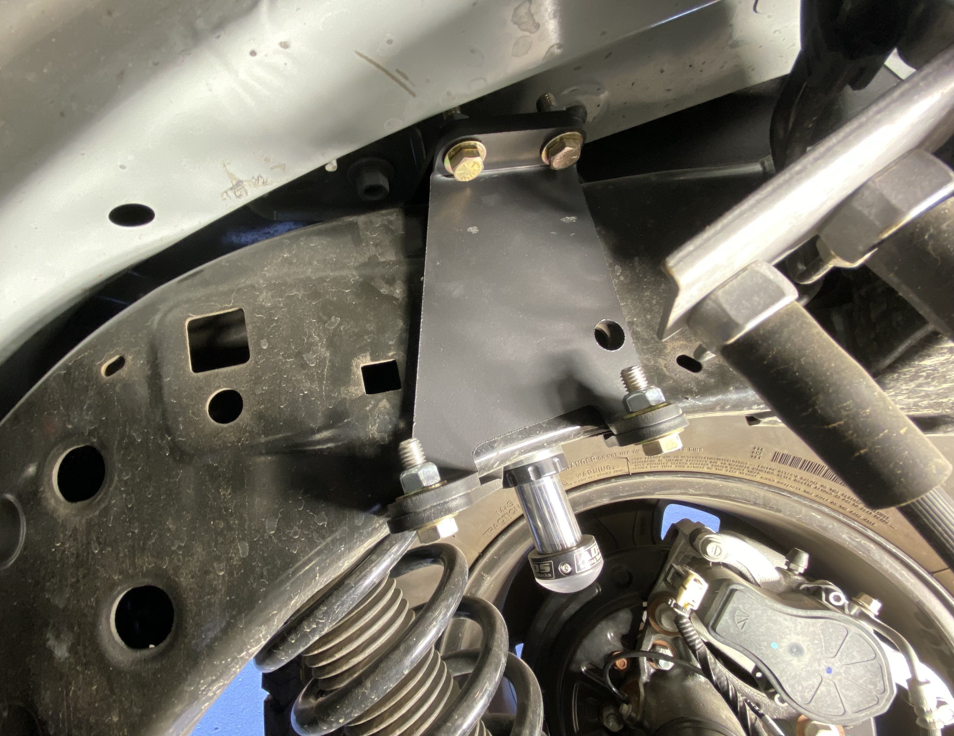 2021 and up Bronco rear hydraulic bump stop kit installed, showcasing mounting bracket and suspension components.