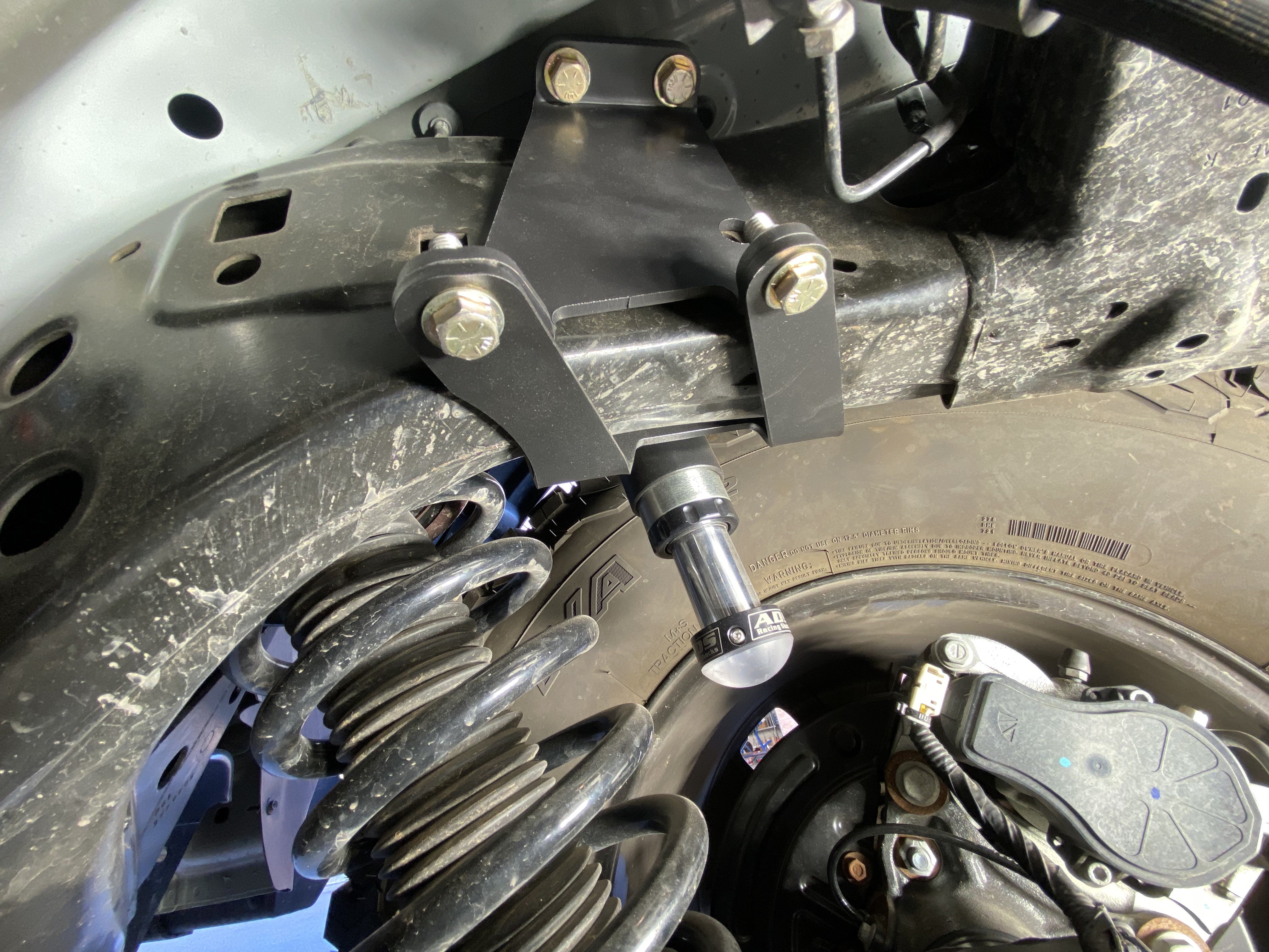 2021 and up Bronco rear hydraulic bump stop kit installed, showcasing mounting hardware and suspension components.