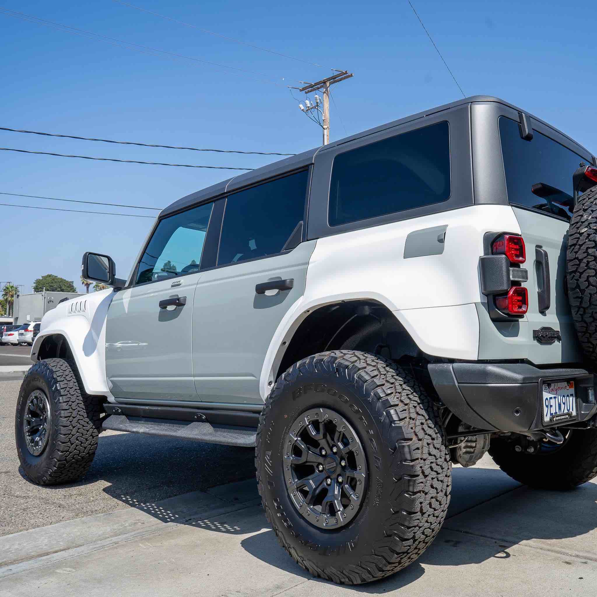 2022-2025 Ford Bronco Raptor rear quarter kit installed on a modified Bronco with oversized tires and a sleek design.