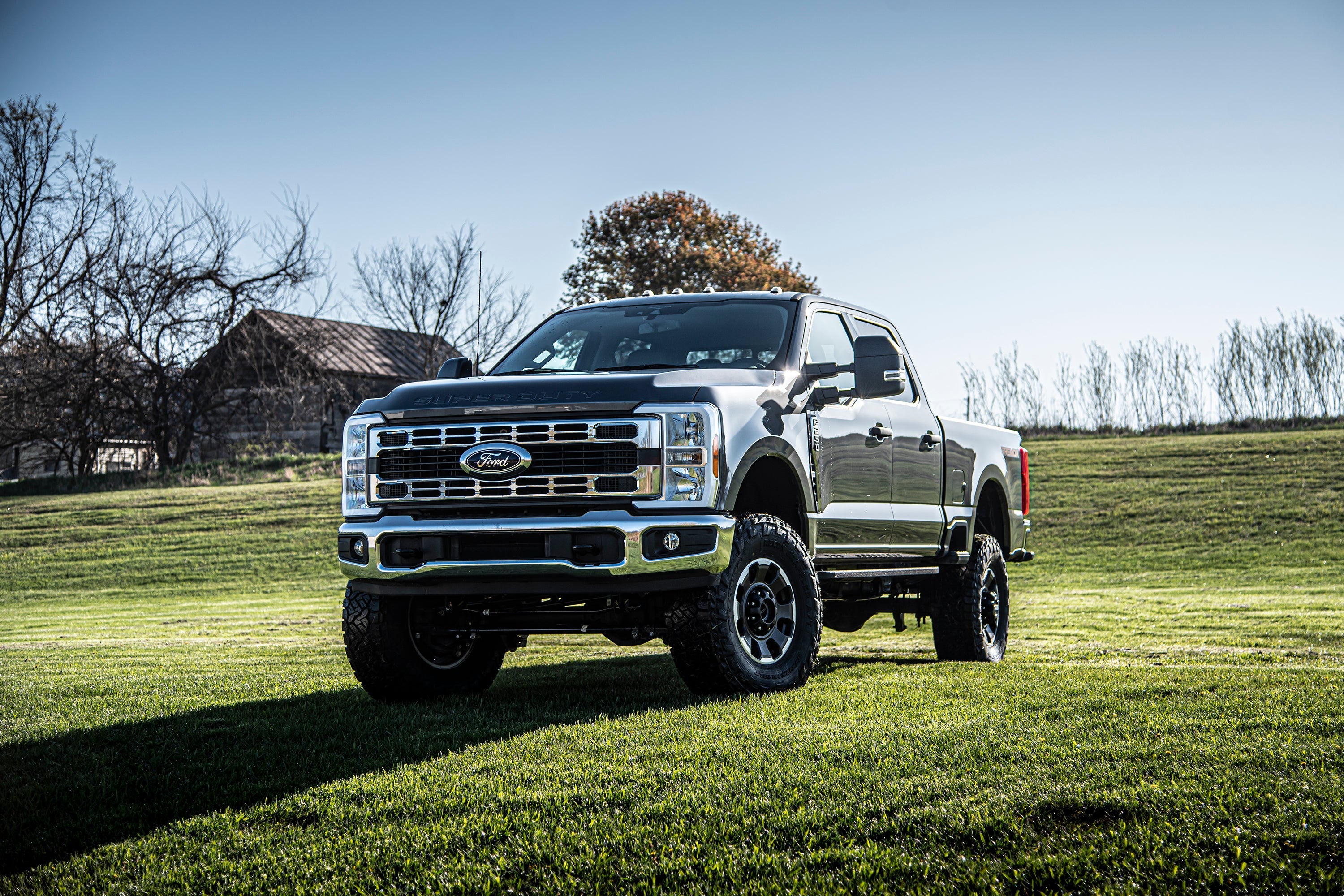 5 inch lift kit with 4-link for Ford F250/F350 Super Duty 4WD (2023-2025) showcased on a lifted truck in a grassy field.