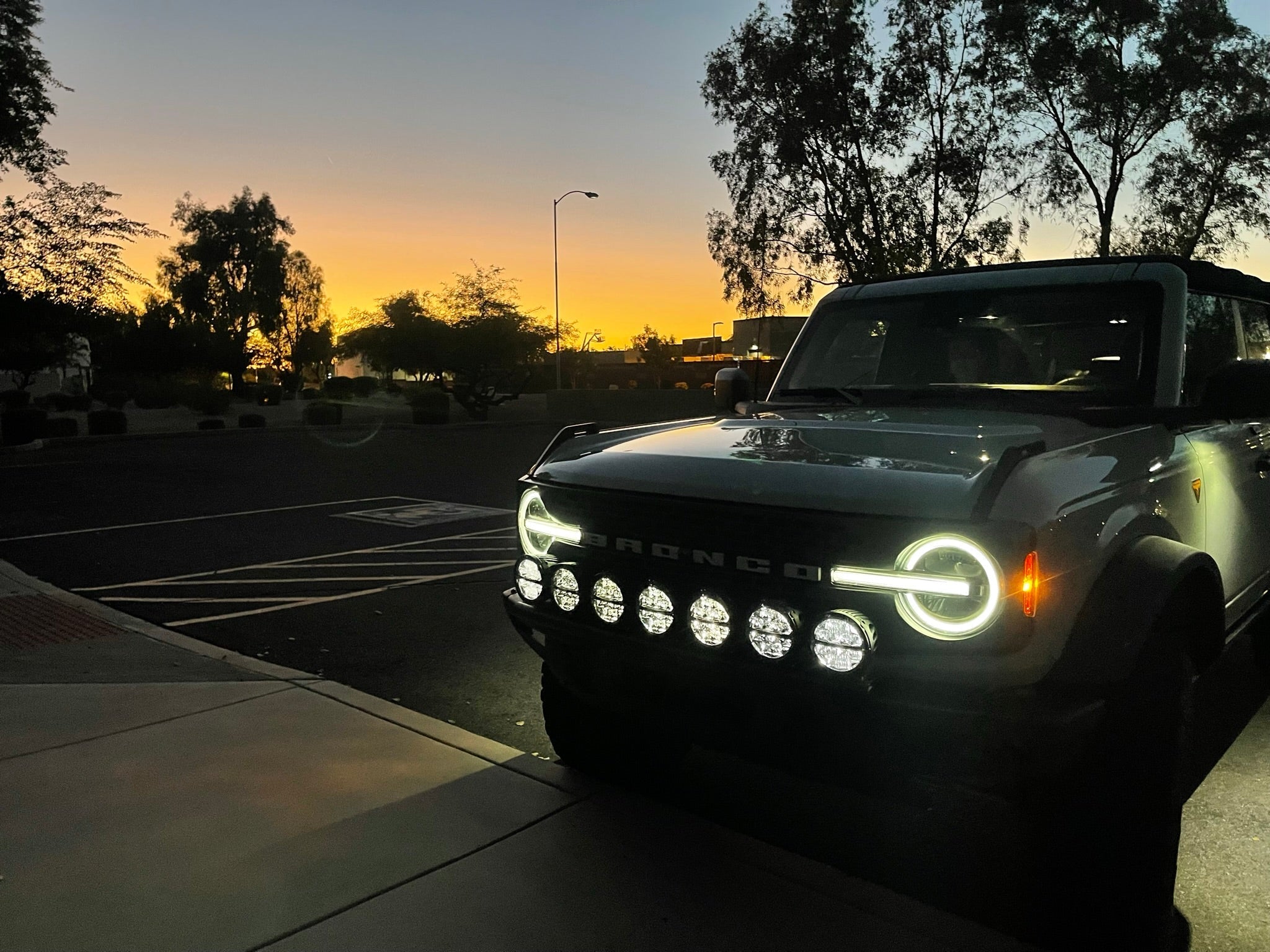 Front light mount kit for 2022-UP Bronco Raptor, showcasing versatile light options against a sunset backdrop.
