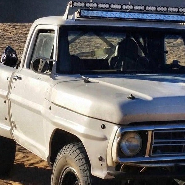 1967-1972 Ford F-100 truck with a rugged frontend, equipped for offroad adventures in a sandy landscape.