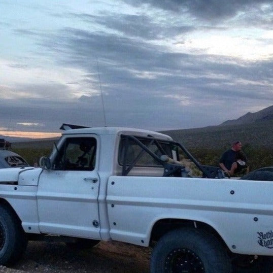 1967-1972 Ford F-100 with custom bedsides parked offroad, showcasing rugged design and offroad capability.