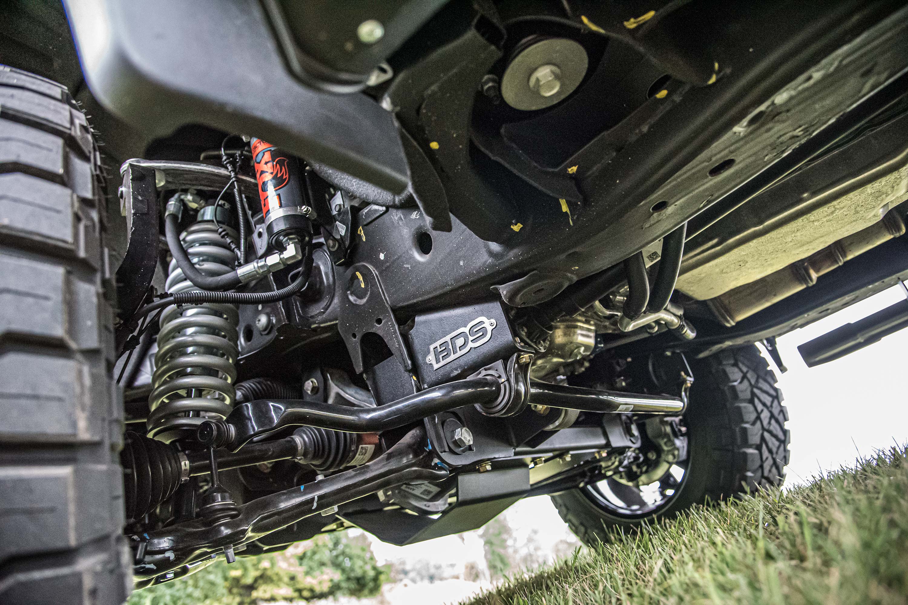 4-inch lift kit installed on a Chevy Silverado or GMC Sierra 1500, showcasing suspension components and undercarriage details.
