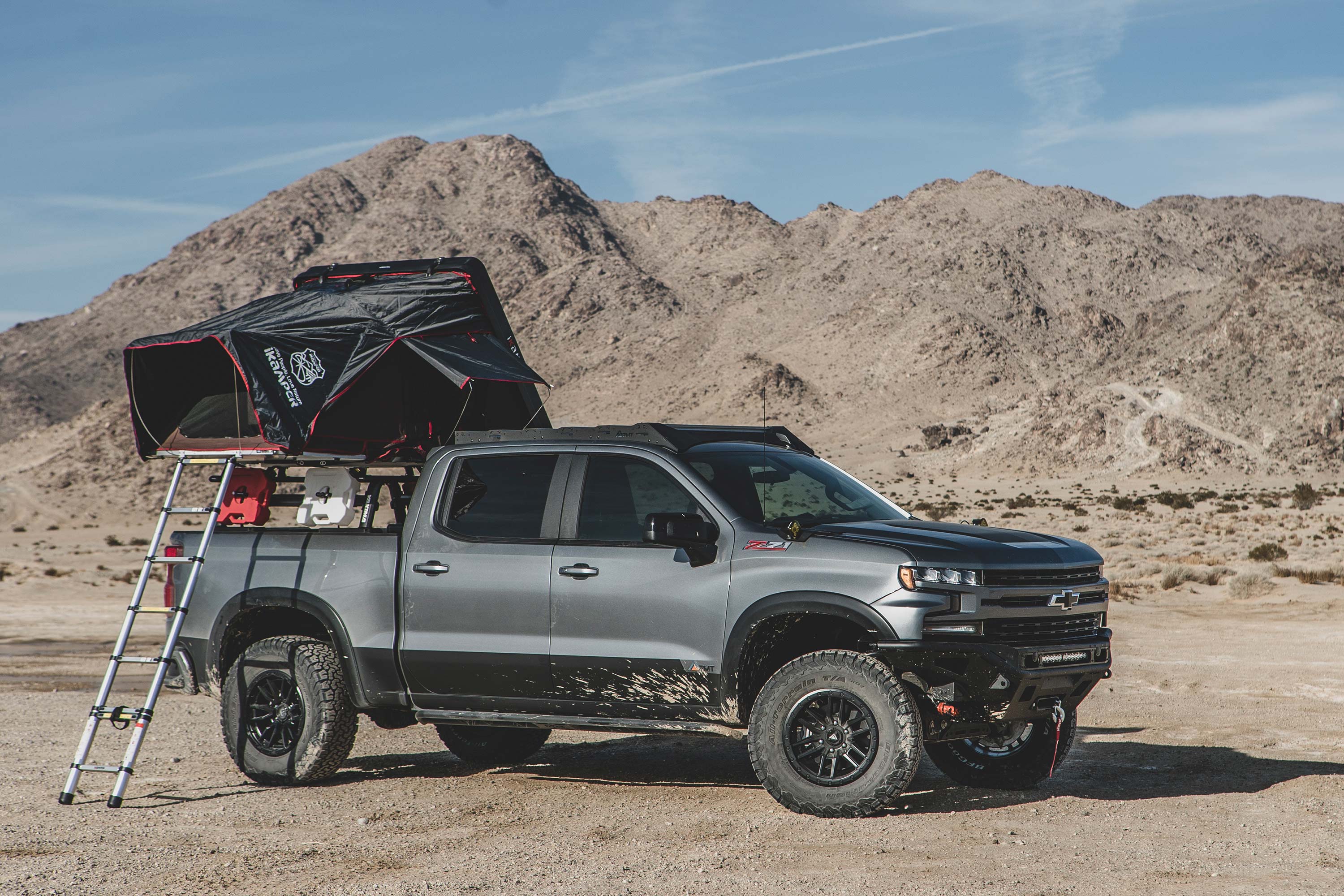 Chevy Trail Boss with a 1.5-inch lift kit and FOX 2.5 coil-over, parked in a desert landscape with a rooftop tent and ladder.