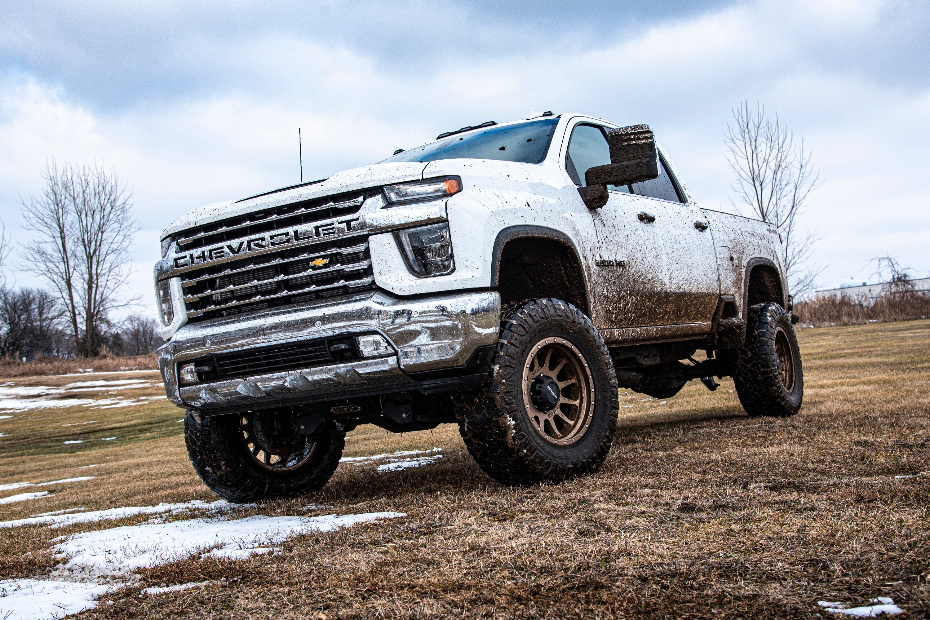 6.5 inch lift kit for Chevy Silverado or GMC Sierra 2500HD/3500HD 4WD, showcasing an elevated truck on rugged terrain.