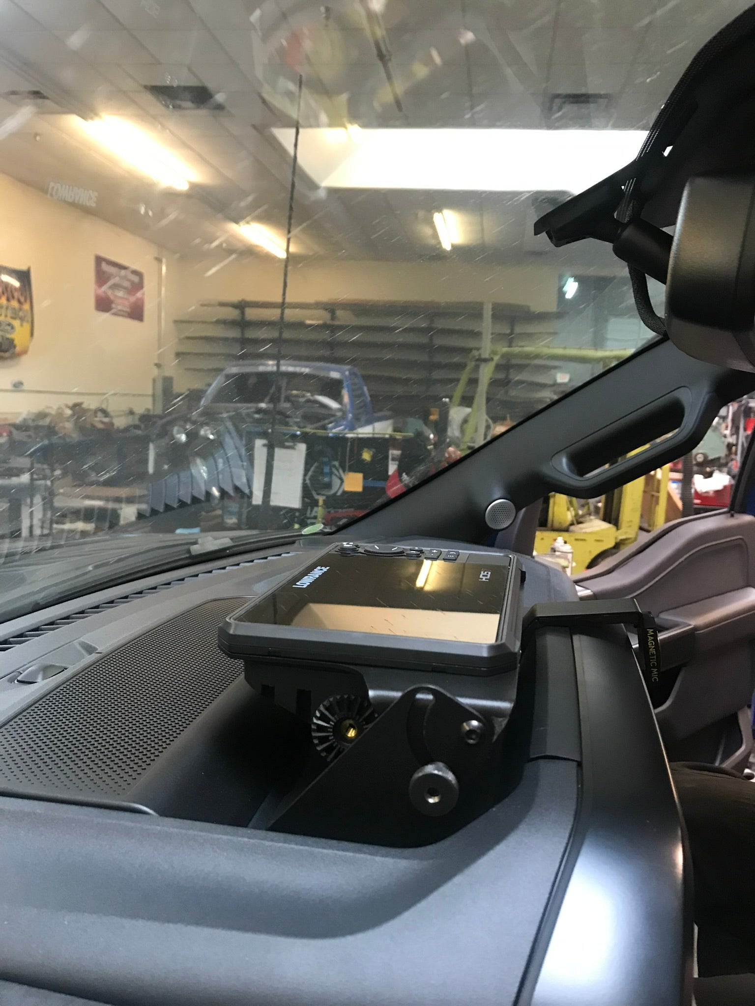 2021-2023 F150 and Gen 3 Raptor center dash fold-down GPS mount for HDS7 Carbon, showcasing installation in a workshop.