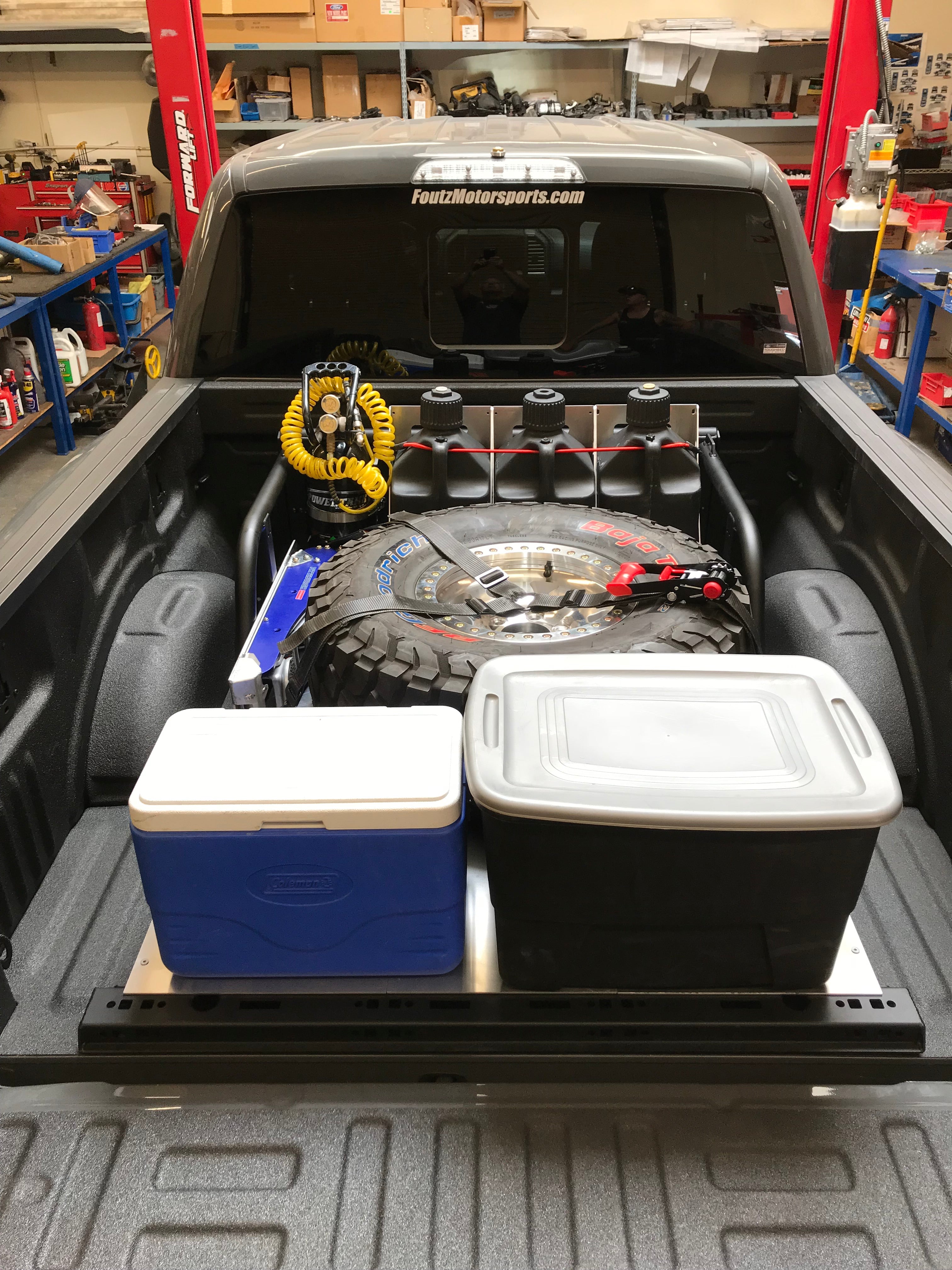 Modular bed organizer for 2017-2024 Ford Raptor and F150, showcasing storage solutions in a truck bed with tools and gear.