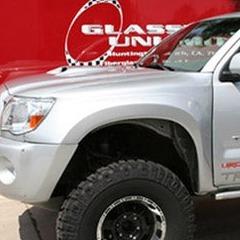2005-2015 Toyota Tacoma fenders installed on a lifted silver truck showcasing offroad capabilities.
