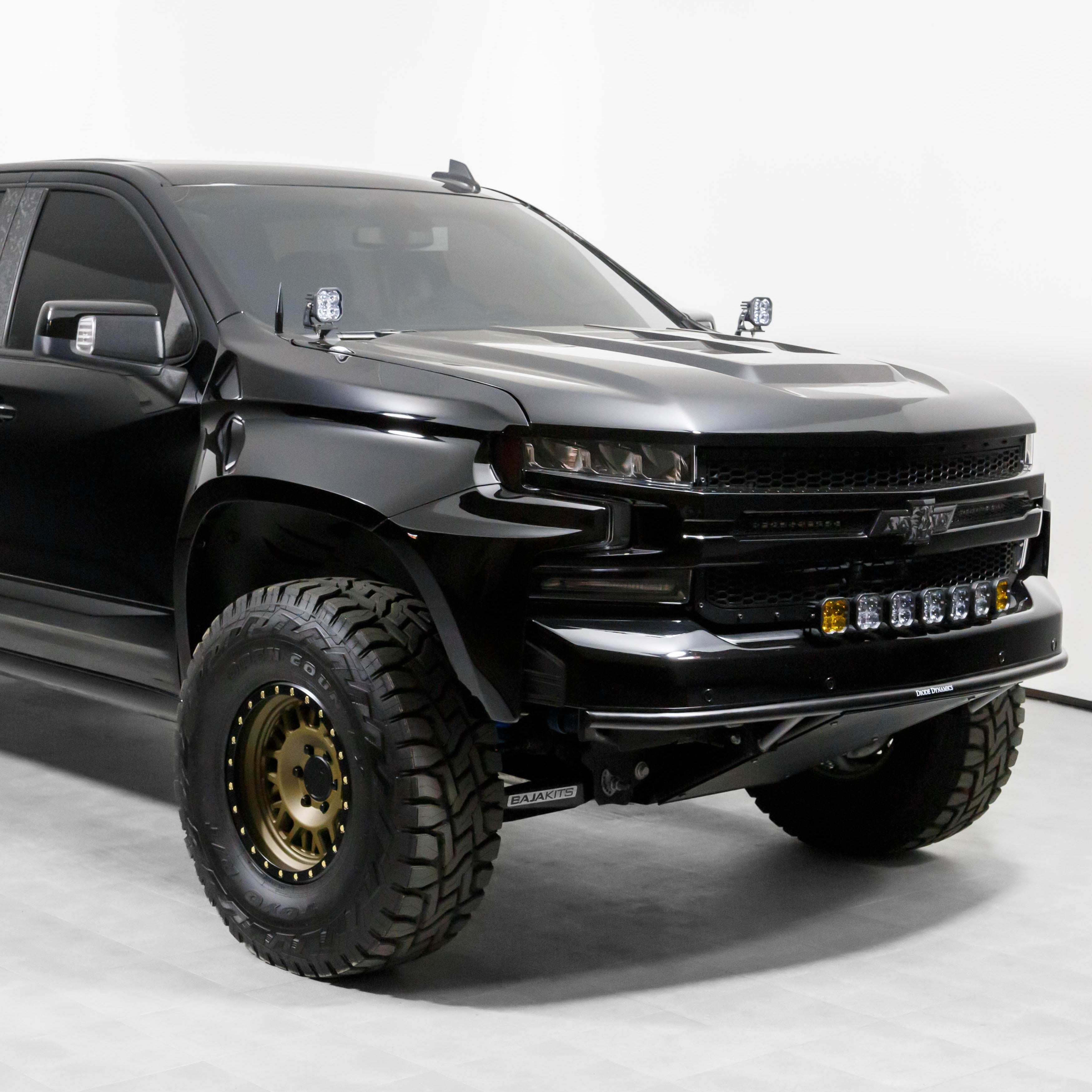 2019-2025 Chevrolet Silverado fenders on a modified black truck with offroad tires and front light bar.