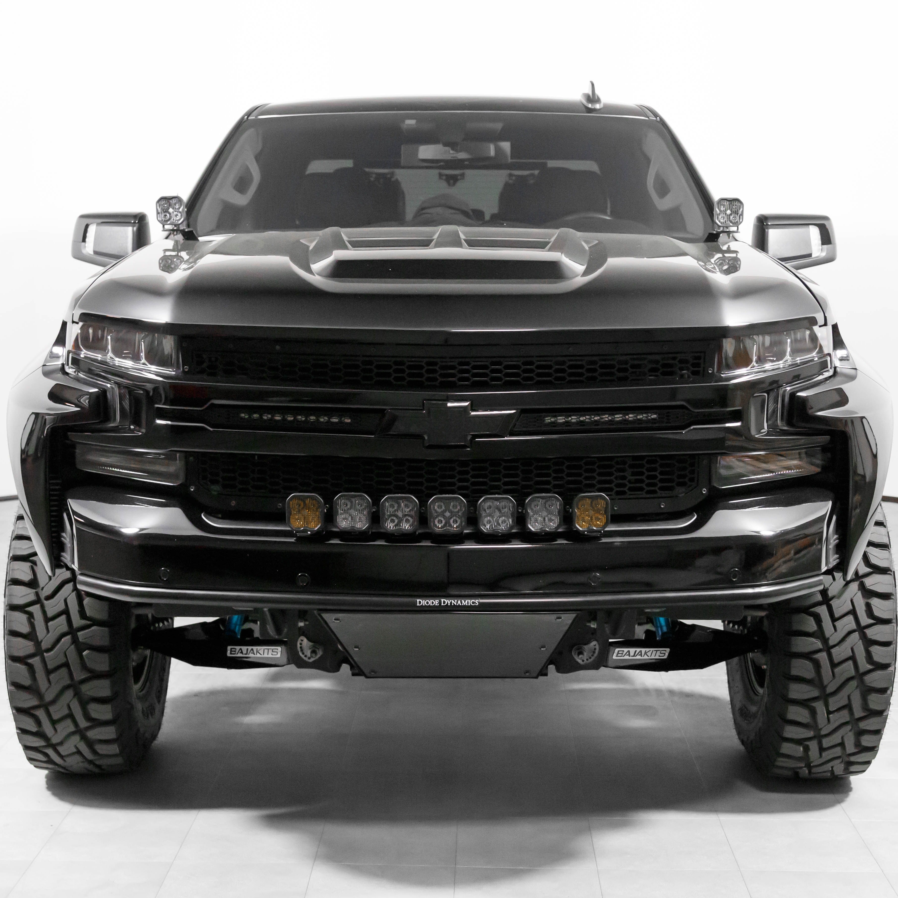 Front view of a modified 2019-2025 Chevrolet Silverado with aftermarket fenders and offroad lights, showcasing rugged design.