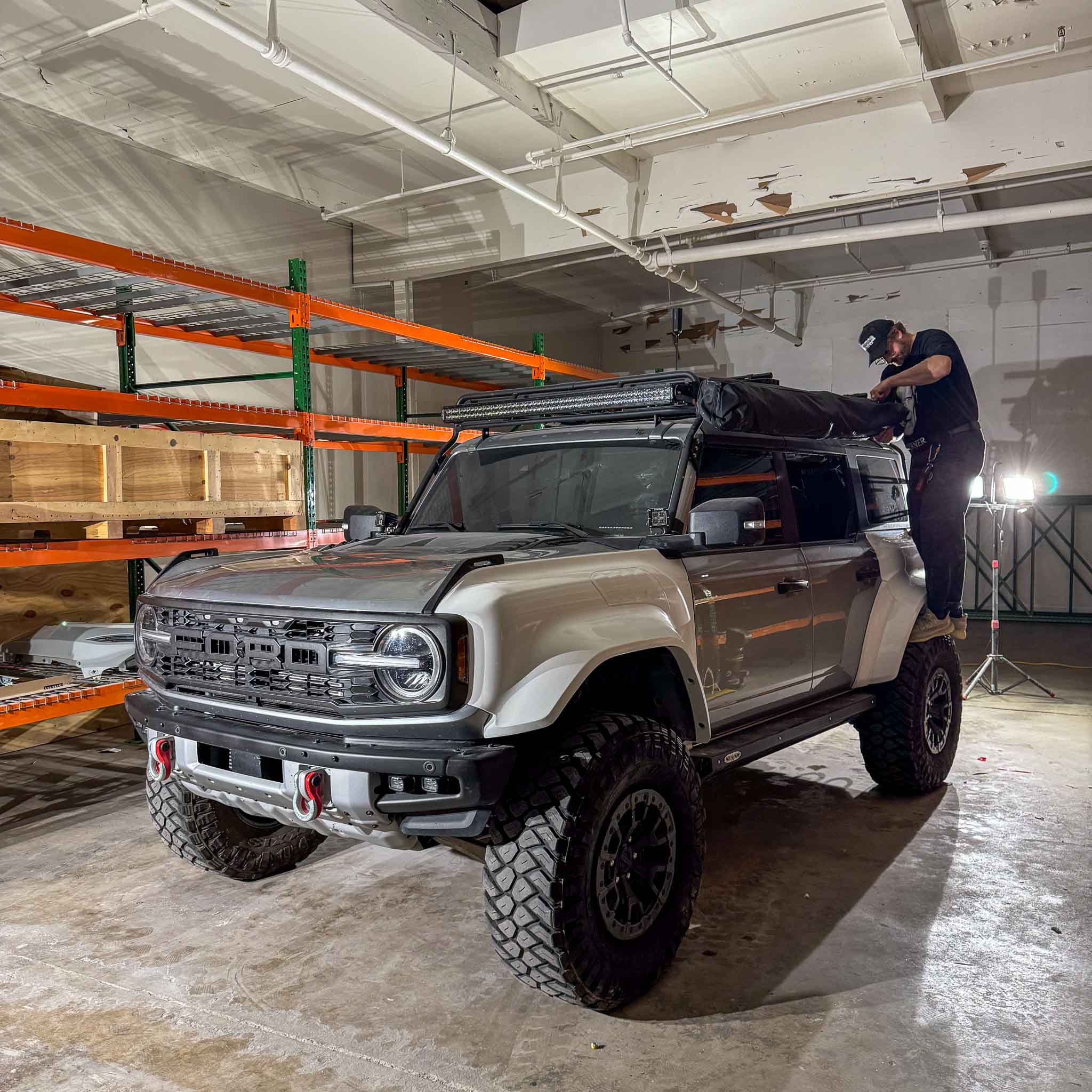 2022-2025 Ford Bronco Raptor with a rear quarter kit, showcasing offroad capabilities in a warehouse setting.