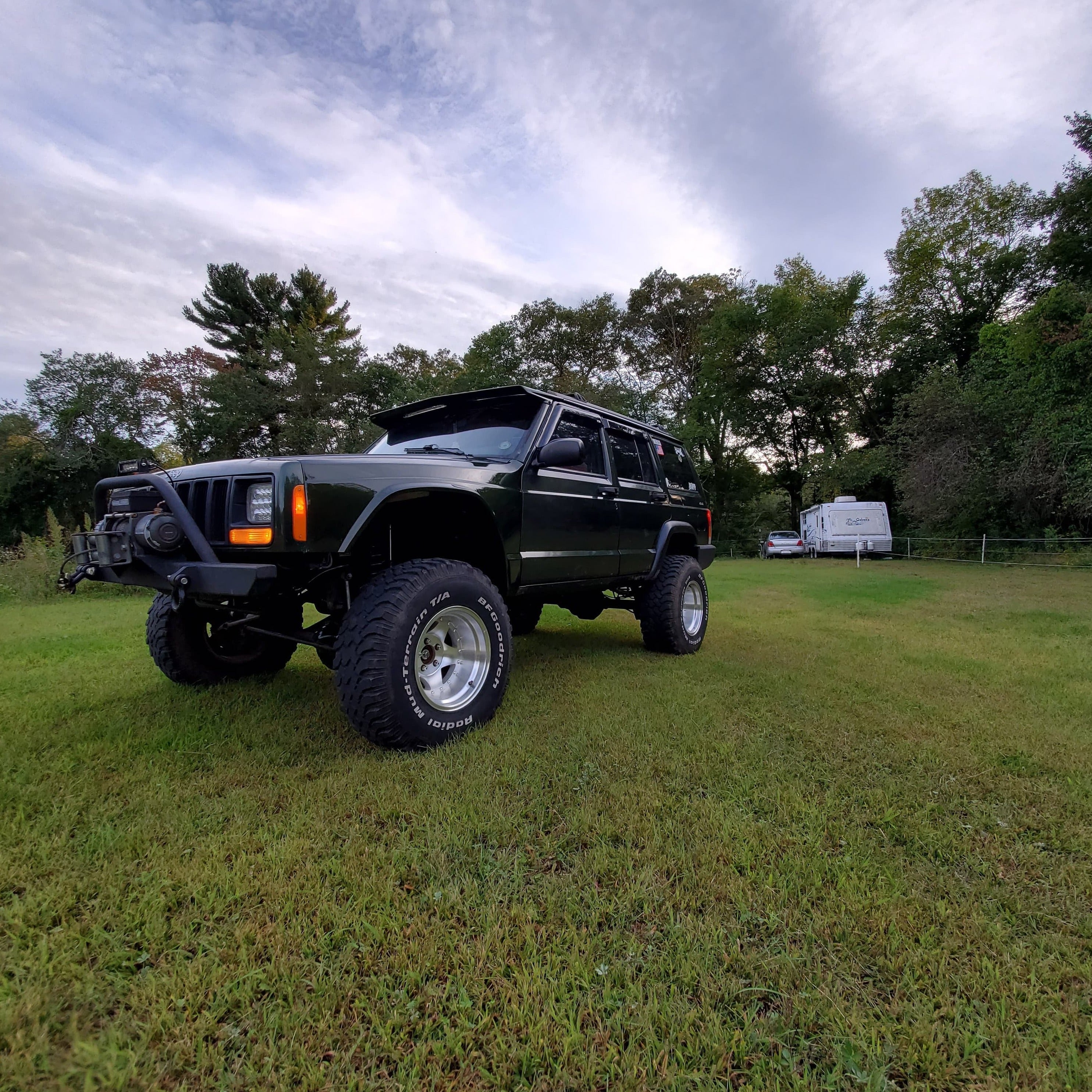 1986-1992 Jeep Comanche fenders displayed on a lifted Jeep in a grassy field, showcasing rugged offroad style.