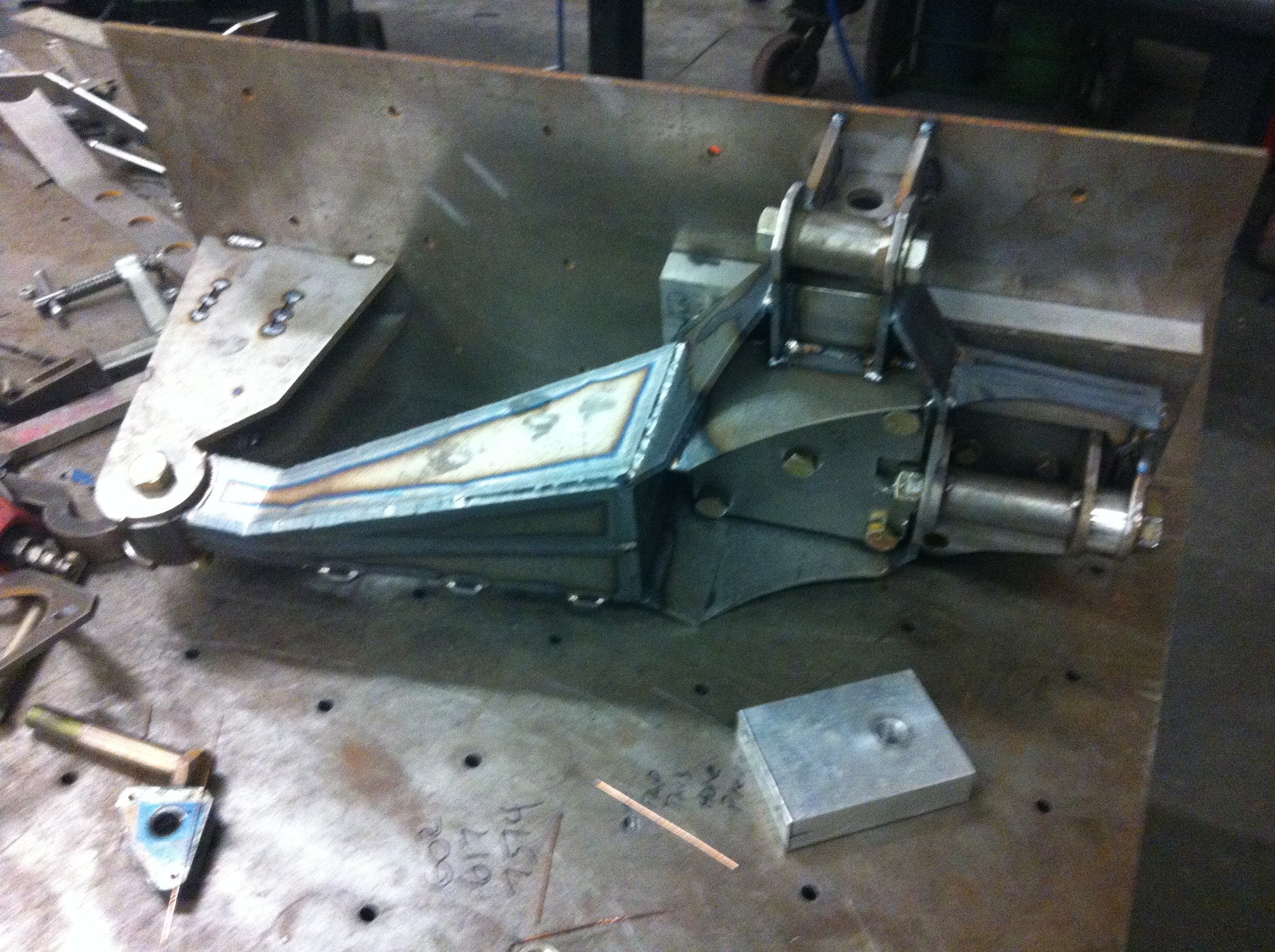 Long travel front suspension kit for 2010-2014 Raptor, showcasing metal components and fabrication details for offroad performance.