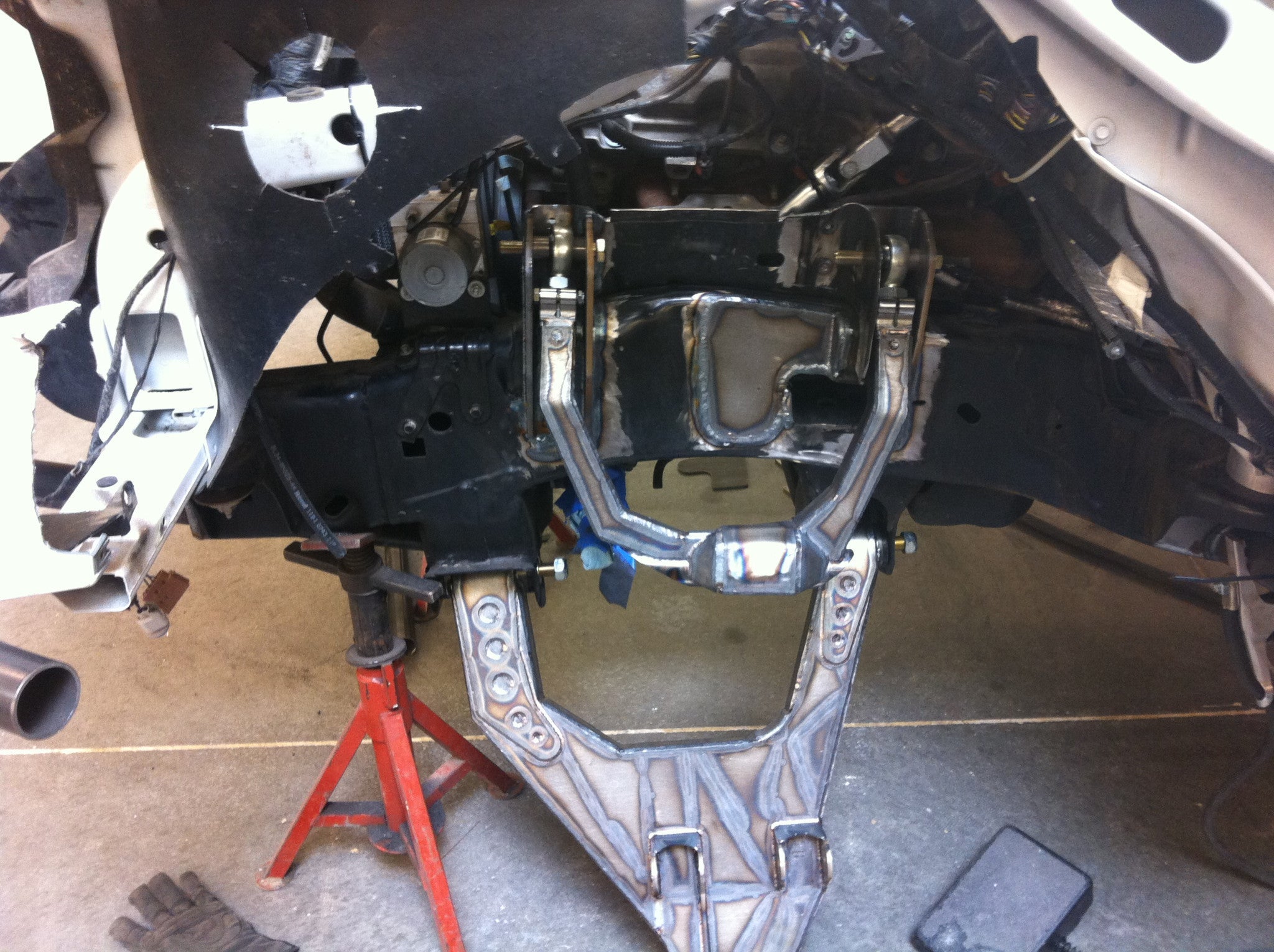 Long travel front suspension kit for 2010-2014 Raptor, showcasing installation with components and tools visible.